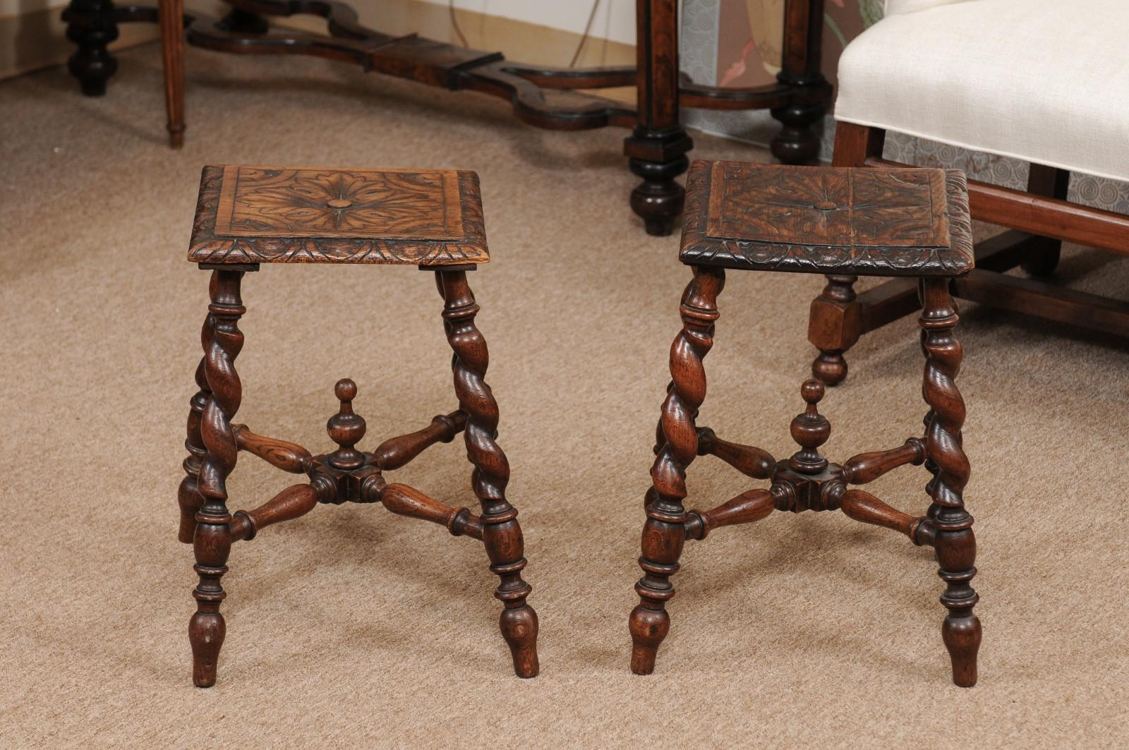 The pair of early 19th century Jacobean style stools with foliate carved seats, barley twist stools joined by turned stretcher with turned finial.