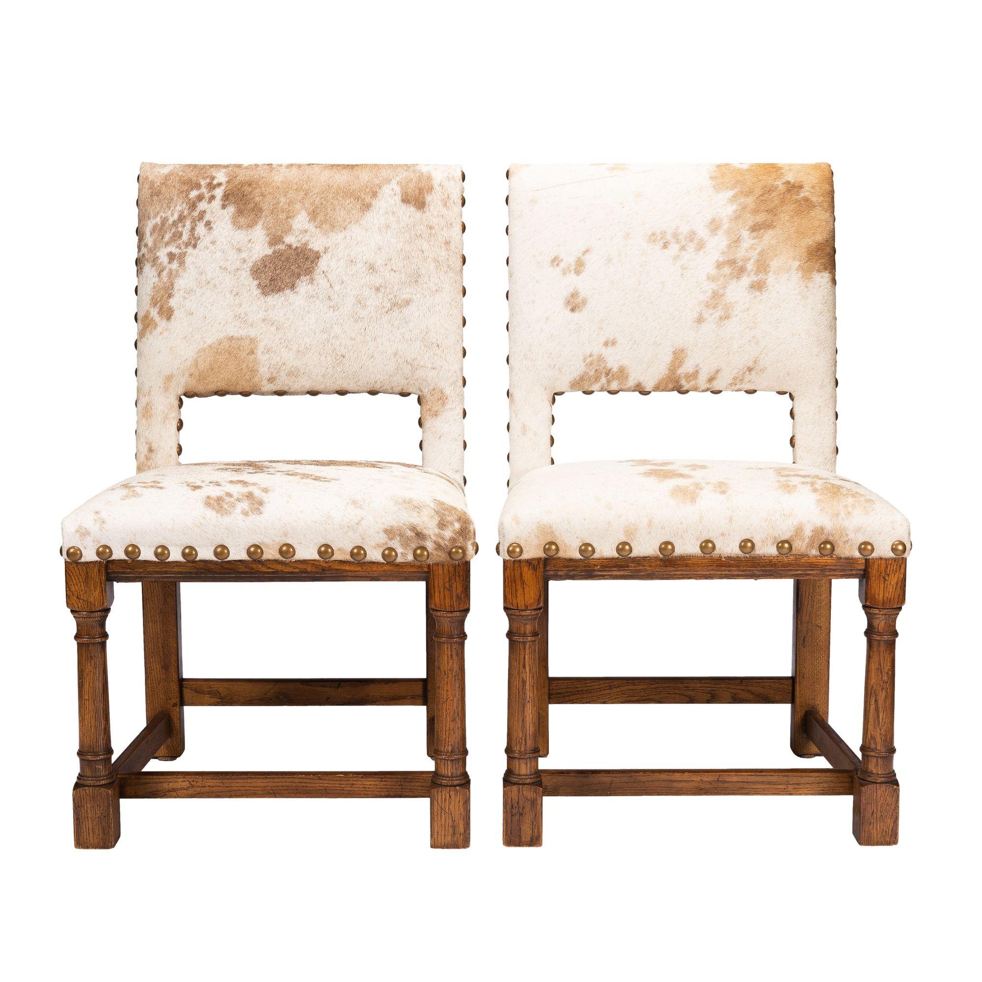 Pair of Academic Revival, Jacobean style, oak framed side chairs upholstered in calf hide with brass nail head trim. The upholstered square chair back continues into square back legs opposite columnar turned front legs attached to the corners of the