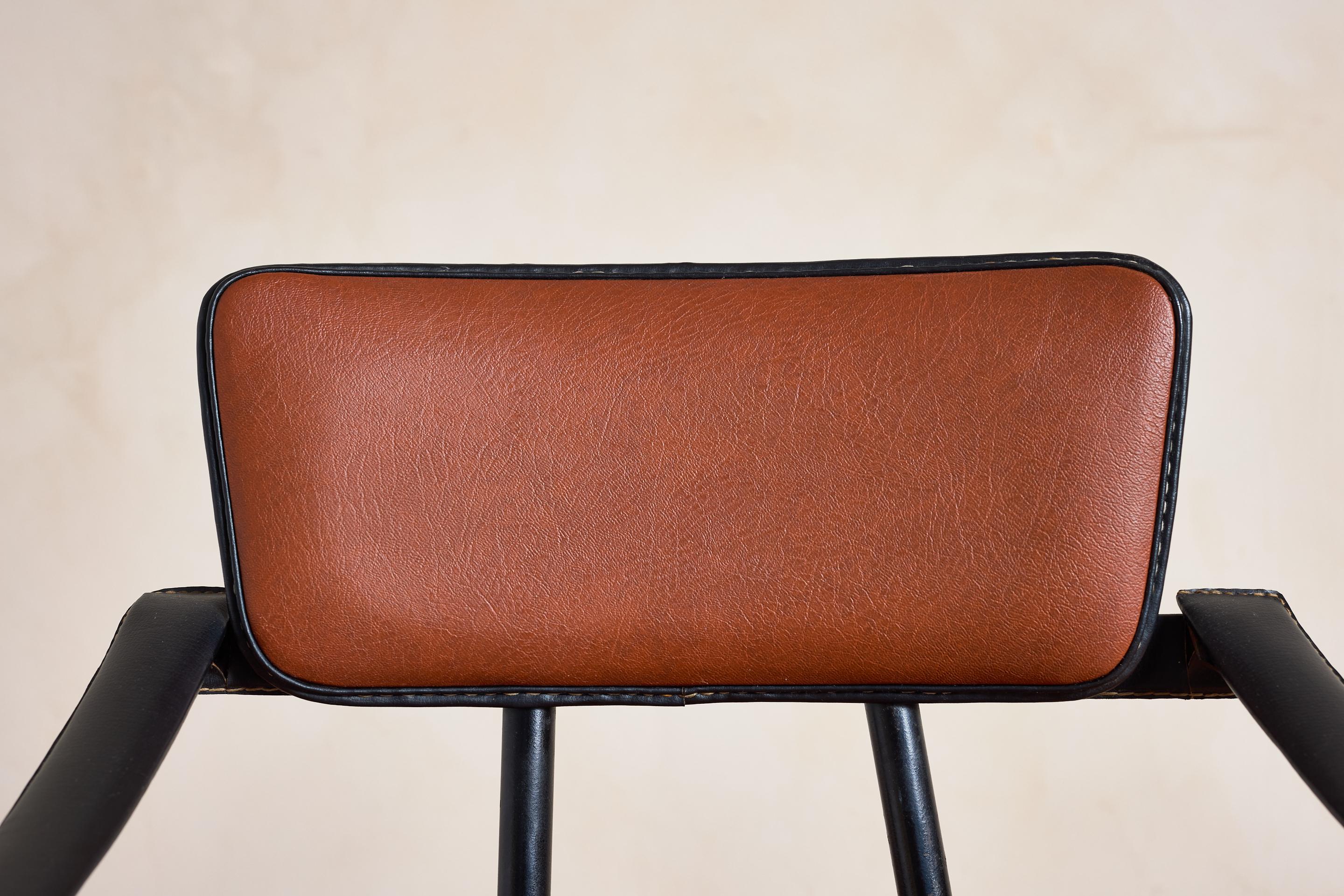 Pair of Jacques Adnet Armchairs - France 1940's

Original  cognac color skai seats and backs with black leather arms and trim with signature contrast stitching. 

Black iron legs and brass accents throughout 
