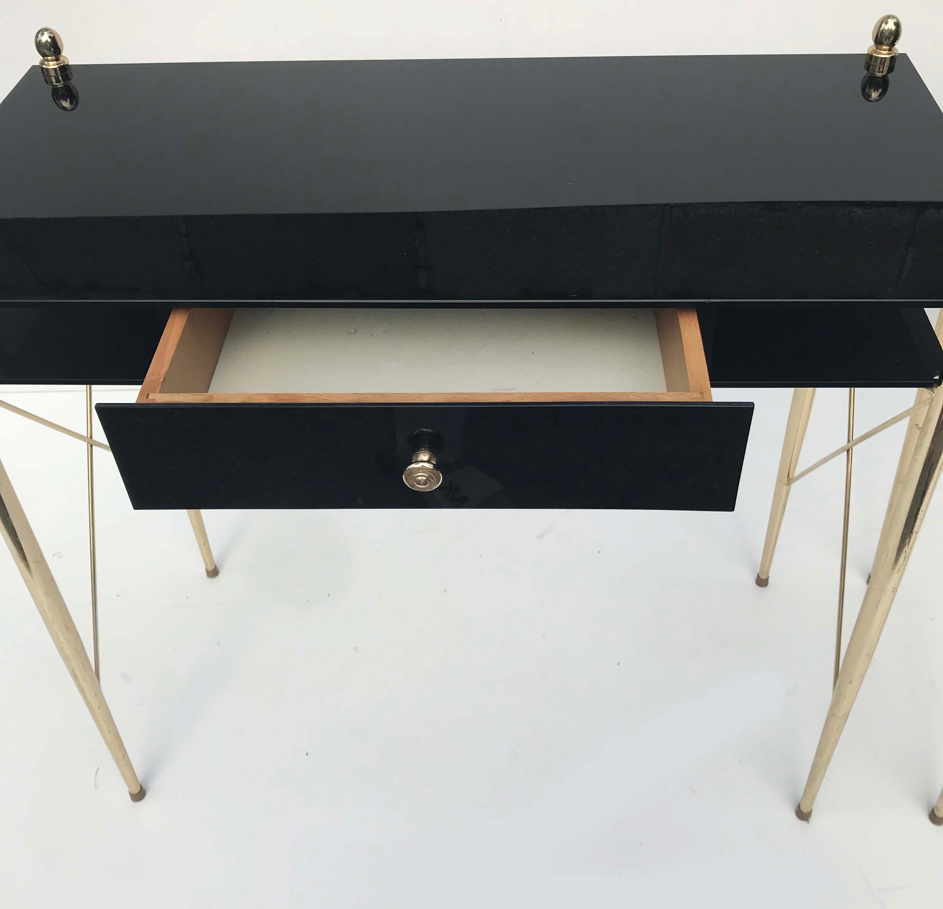 Superb and rare pair of Brass & Black Opaline Glass Consoles in the style of Jacques Adnet.
1 central drawer and brass ornaments.
29 inches Height with the finial.
  