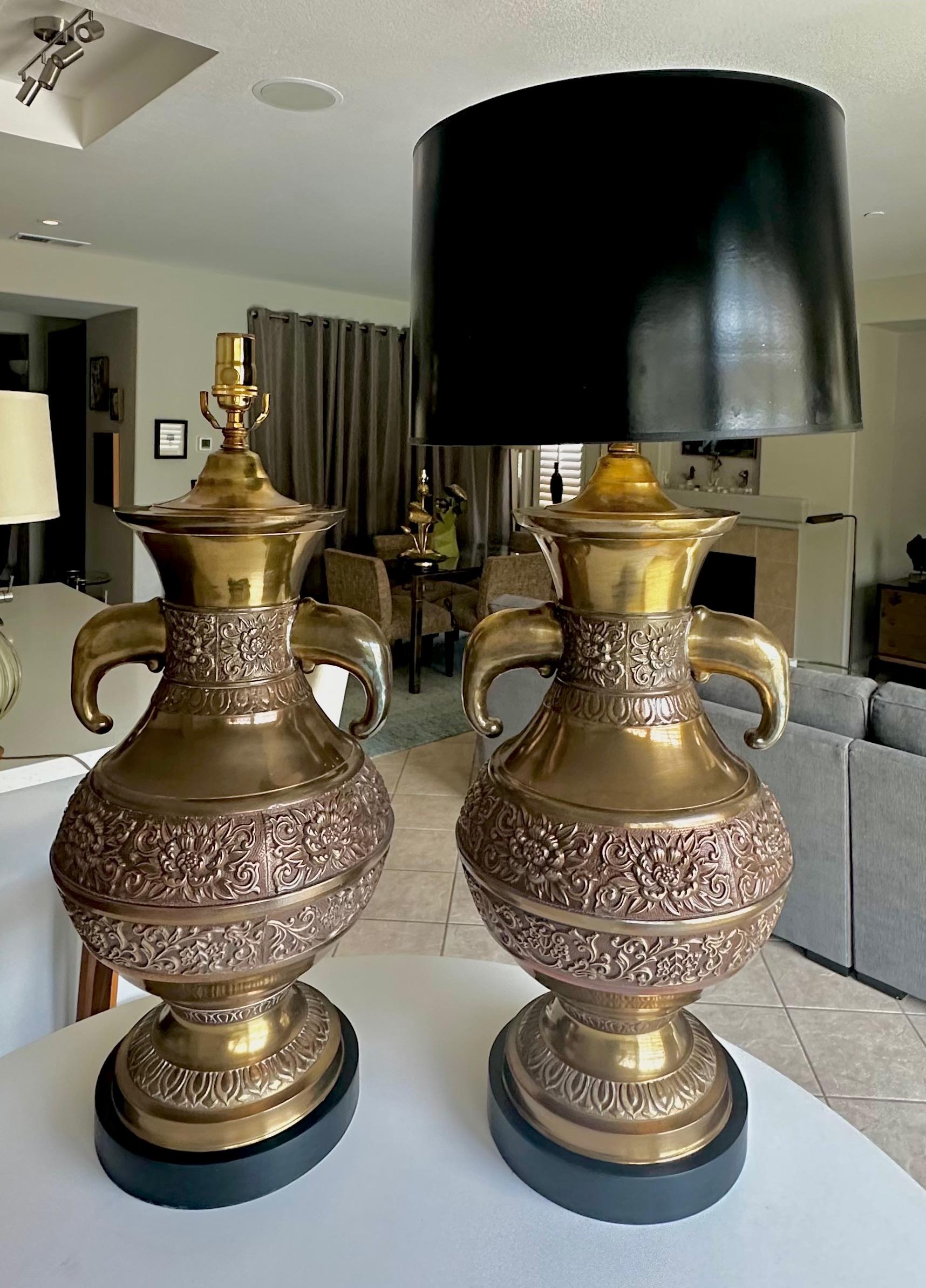 Paire de grandes lampes de table en laiton d'inspiration asiatique avec un design géométrique moulé et des poignées en forme de tête d'éléphant. Montés sur des bases laquées noires. Nouveau câblage pour les États-Unis avec de nouvelles prises à