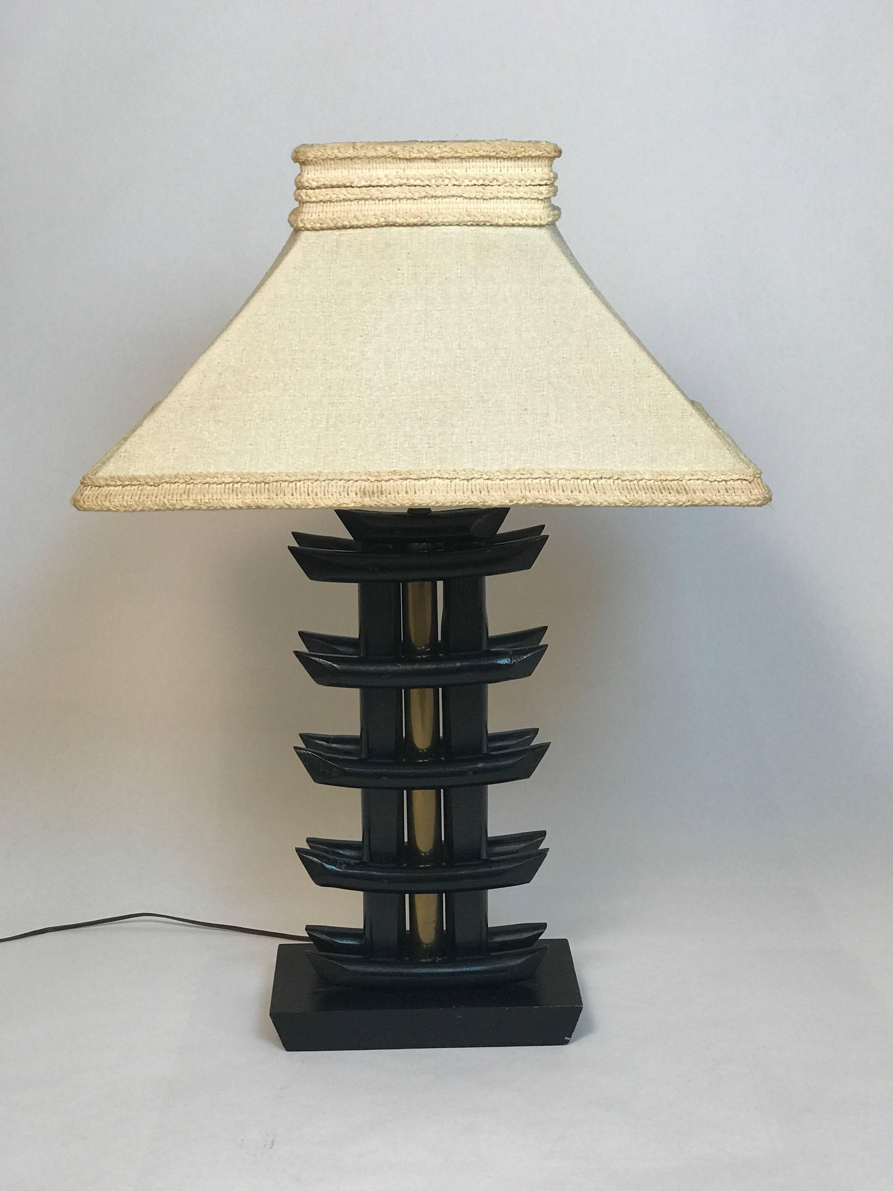 Gorgeous early pair of lamps possibly James Mont. The original ivory color fabric with trim shades are incredible and becoming harder and harder to find in this condition. The base is ebonized solid wood with the body being constructed of ebonized