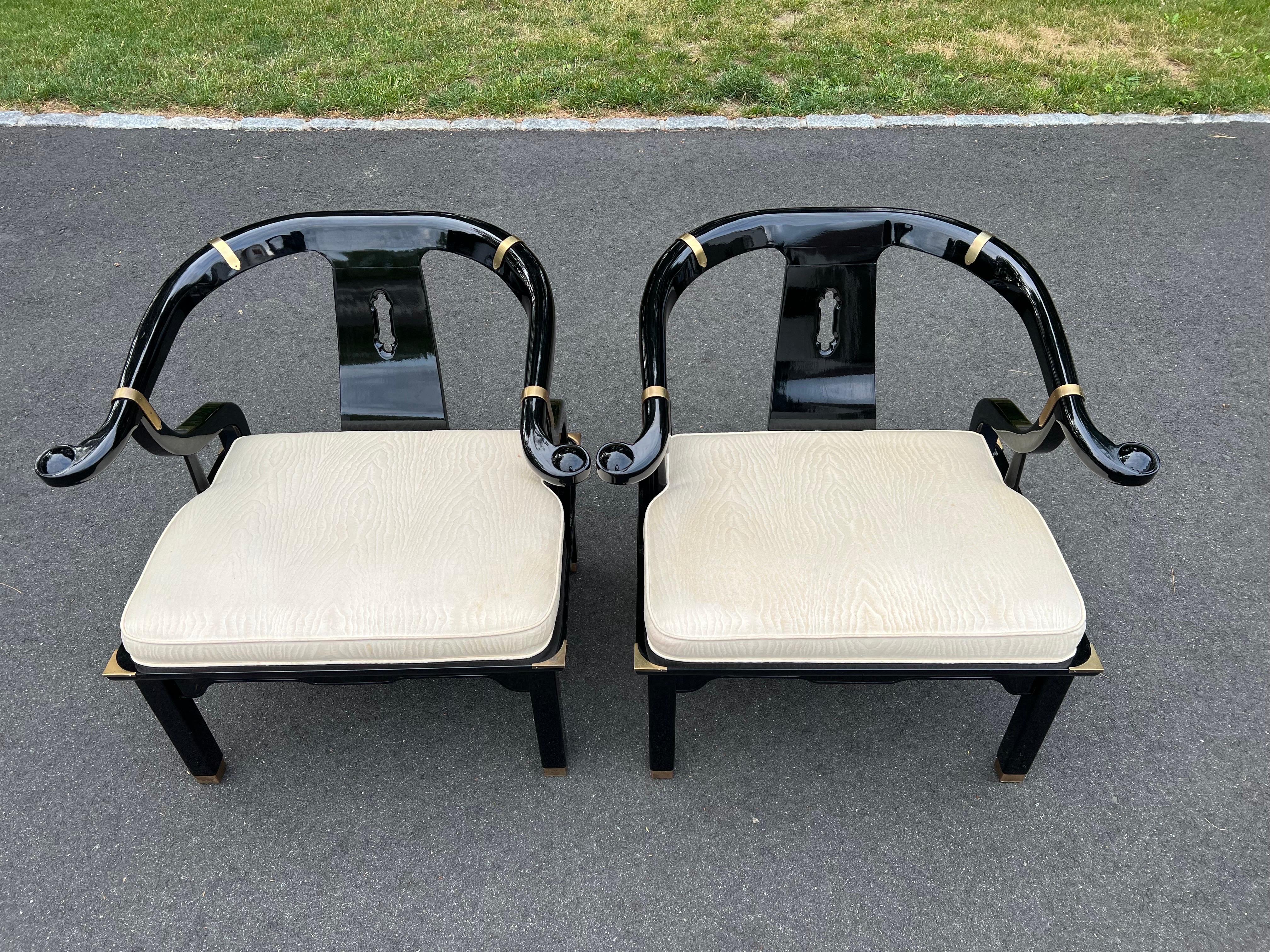 Pair of James Mont for Century Lacquered Horseshoe Chairs. Classic Asian Ming design with brass accents. The quintessential designer chairs with cream upholstered seats.