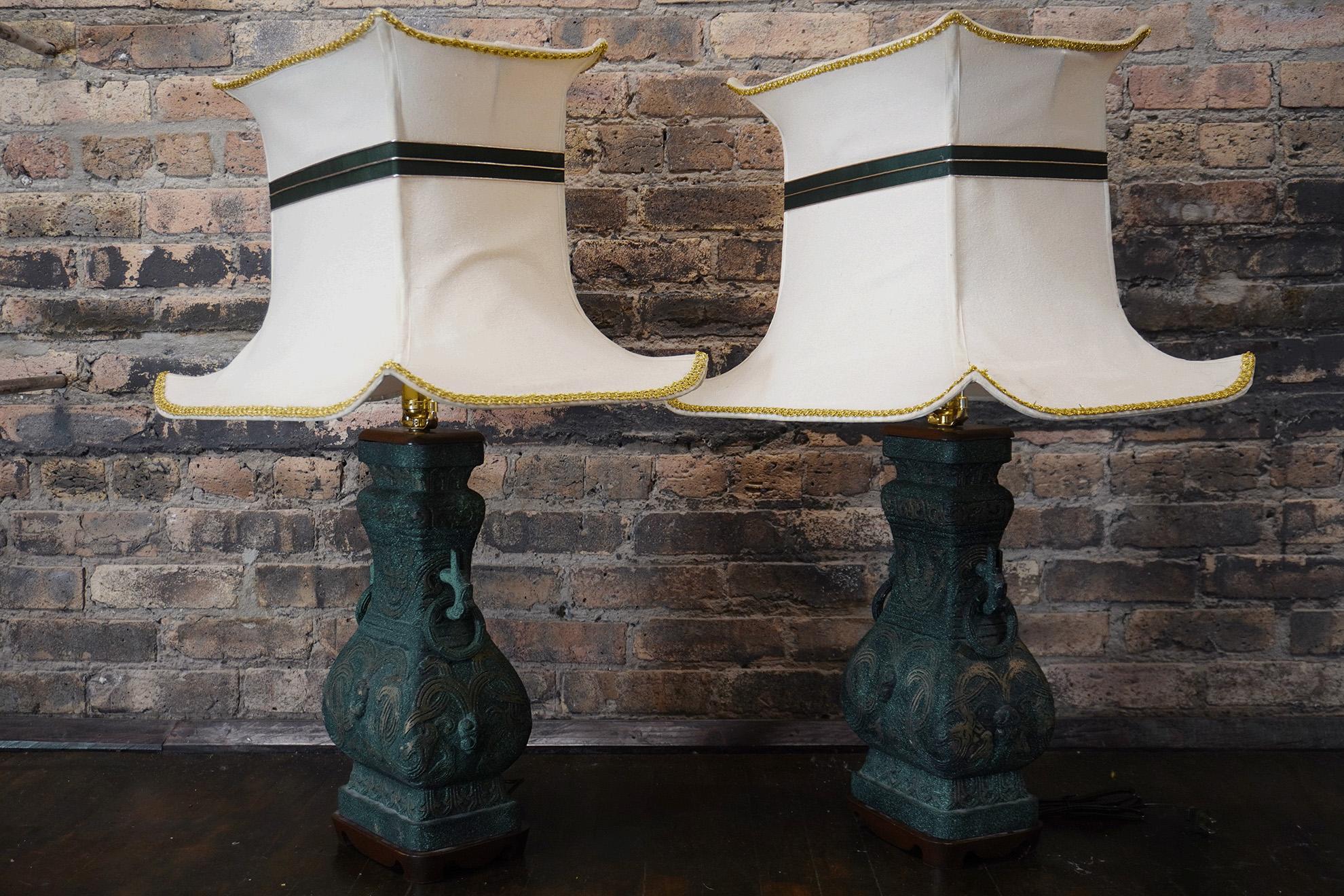Paire monumentale de lampes en bronze en forme d'urne avec une superbe finition vert-de-gris patinée.  Les bases en acajou sculpté présentent une légère usure et des imperfections mineures (voir les images en gros plan).  

Les mesures indiquées