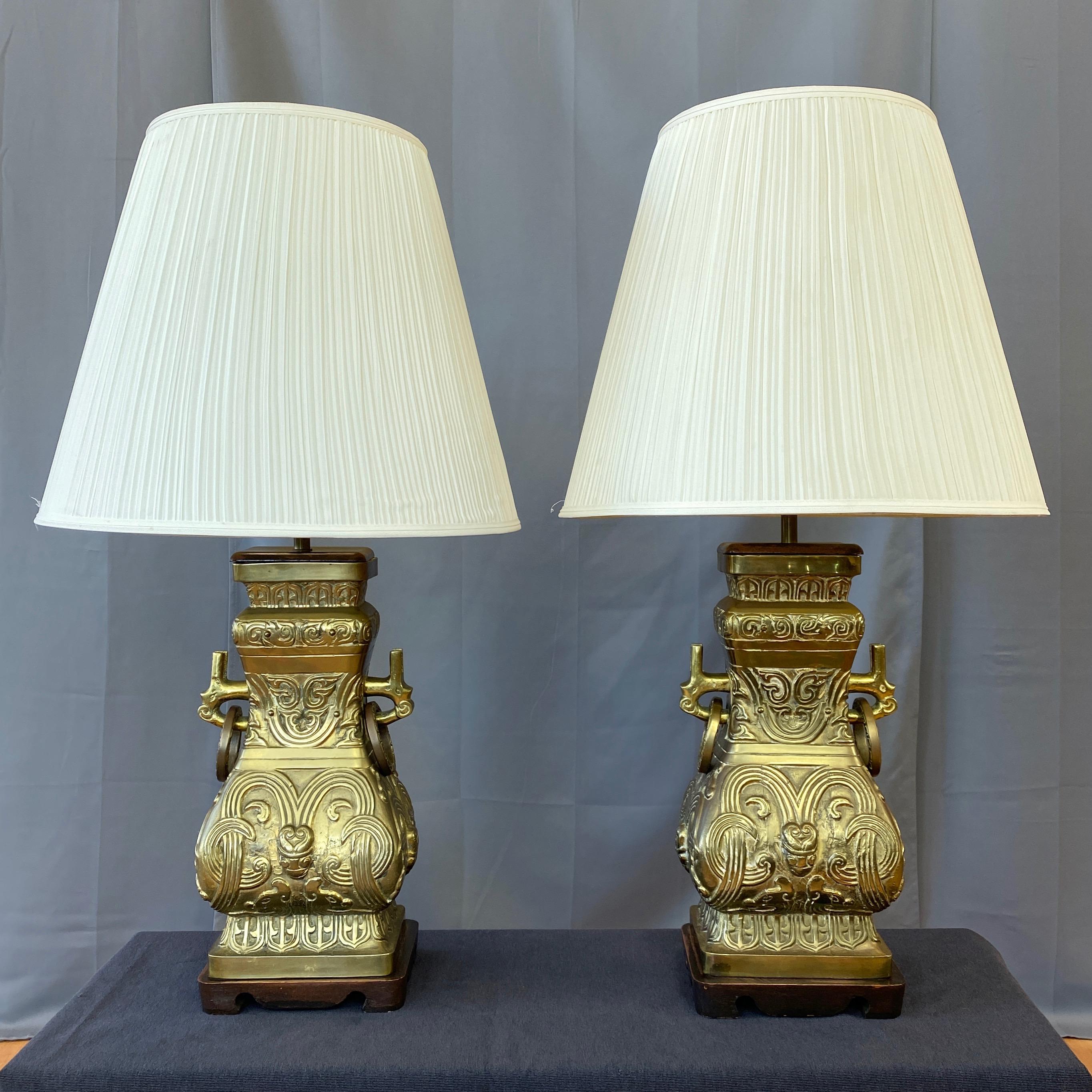 An impressive pair of substantial 1950s Chinese archaistic-style brass table lamps done in the manner of James Mont.

Traditional form being a fang (square) interpretation of hu and gui archaic ritual bronzes from the Shang and Zhou dynasties. Such