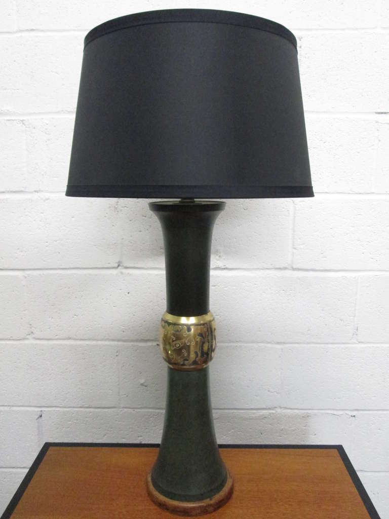 Pair of James Mont style lamps. The lamps have patinated green metal body with wood base and a brass decorative trim. Shades not included. 

Measures: 30