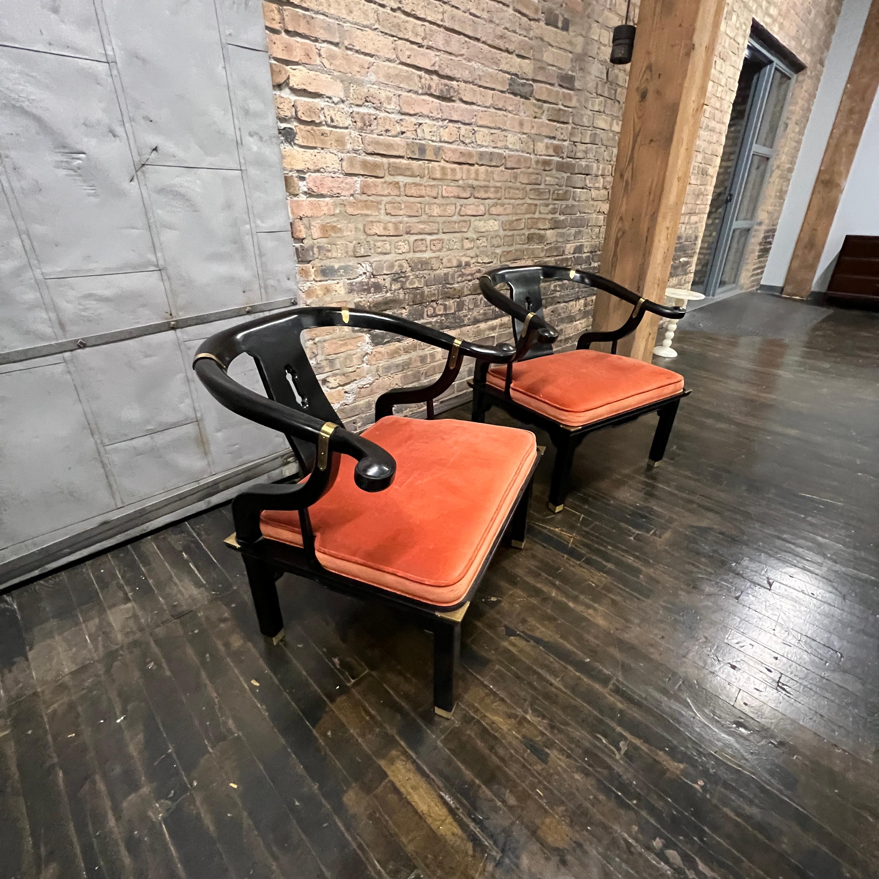 A lovely pair of large Chinese ming style horseshoe lounge chairs made by Century Furniture. Originally designed by James Mont these chairs epitomize his over the top dramatic mid-century modern style with a unique Asian flare. Hardwood frames
