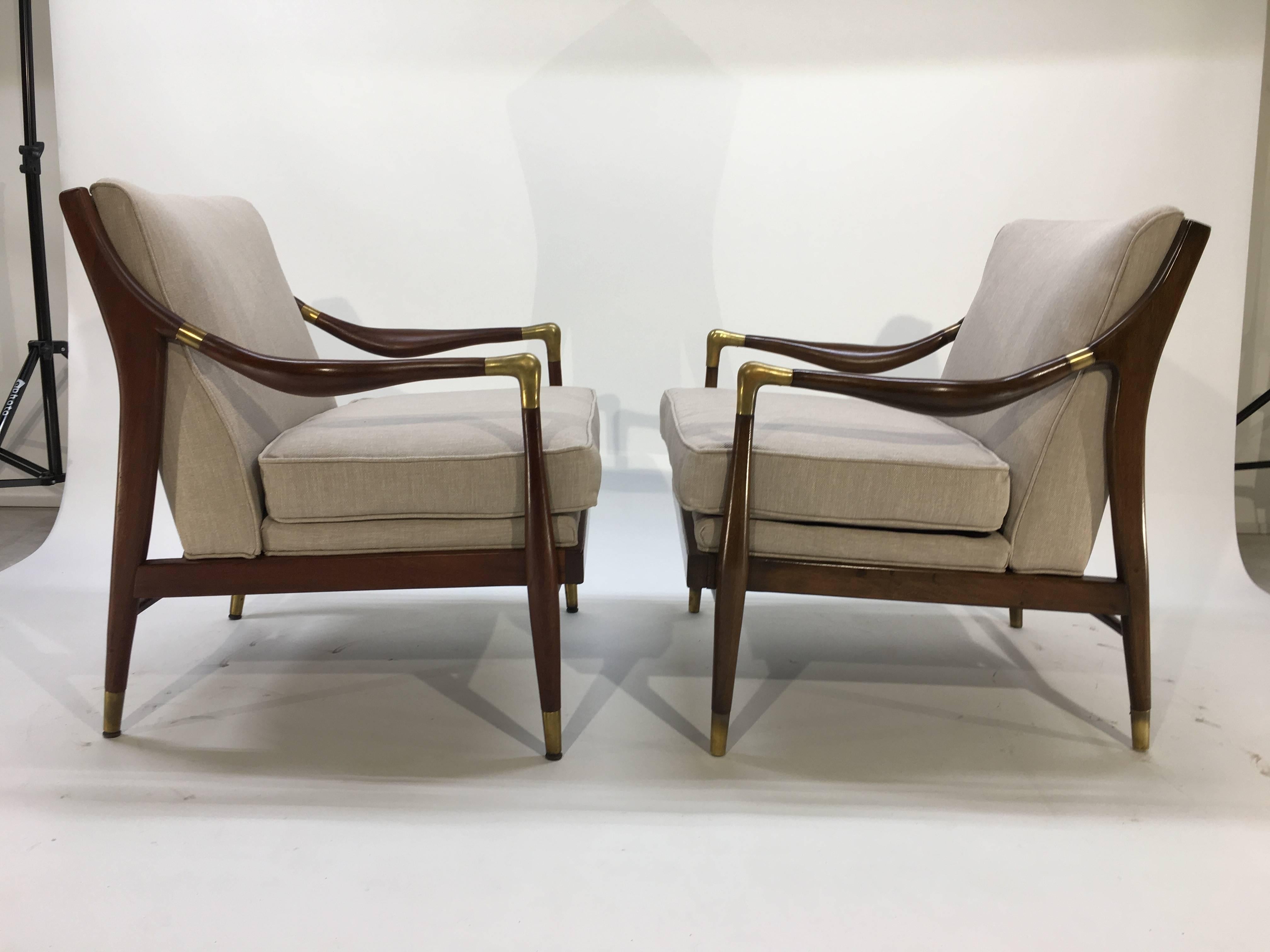 A 1950s pair of sculptural walnut armchairs having solid brass armrest elbows and brass sabots by Jamestown Royal.
Newly reupholstered with fresh cushioning. Ready for use.
    
