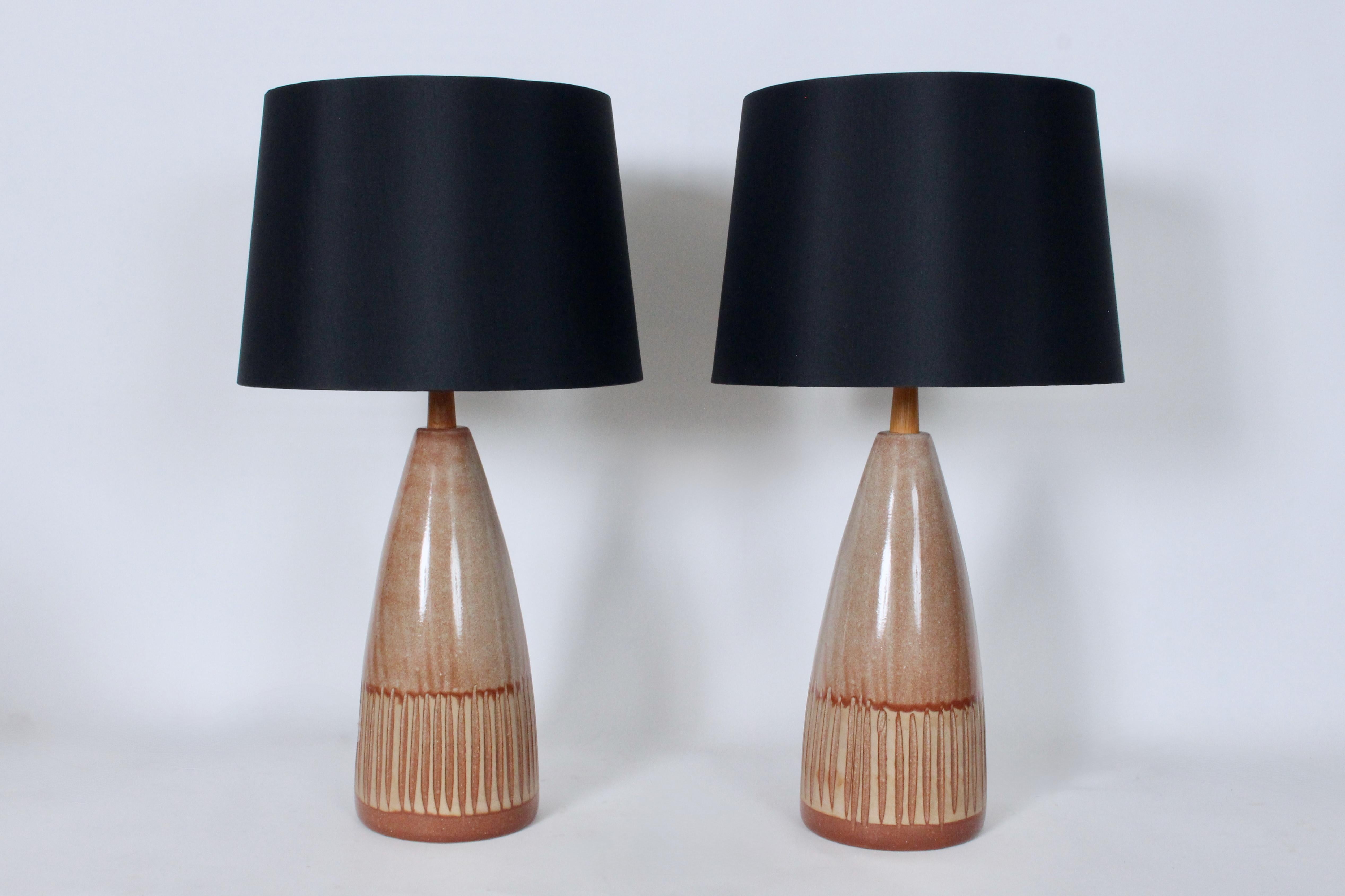 Jane & Gordon Martz Marshall Studios Inc. Caramel Pottery Table Lamps.
Featuring handcrafted, incised bullet, glazed Stoneware forms, Teak necks, with coloration ranging darker, Pantone 471 to lighter 473 and lightest 4665. Sand like effect. 21H to
