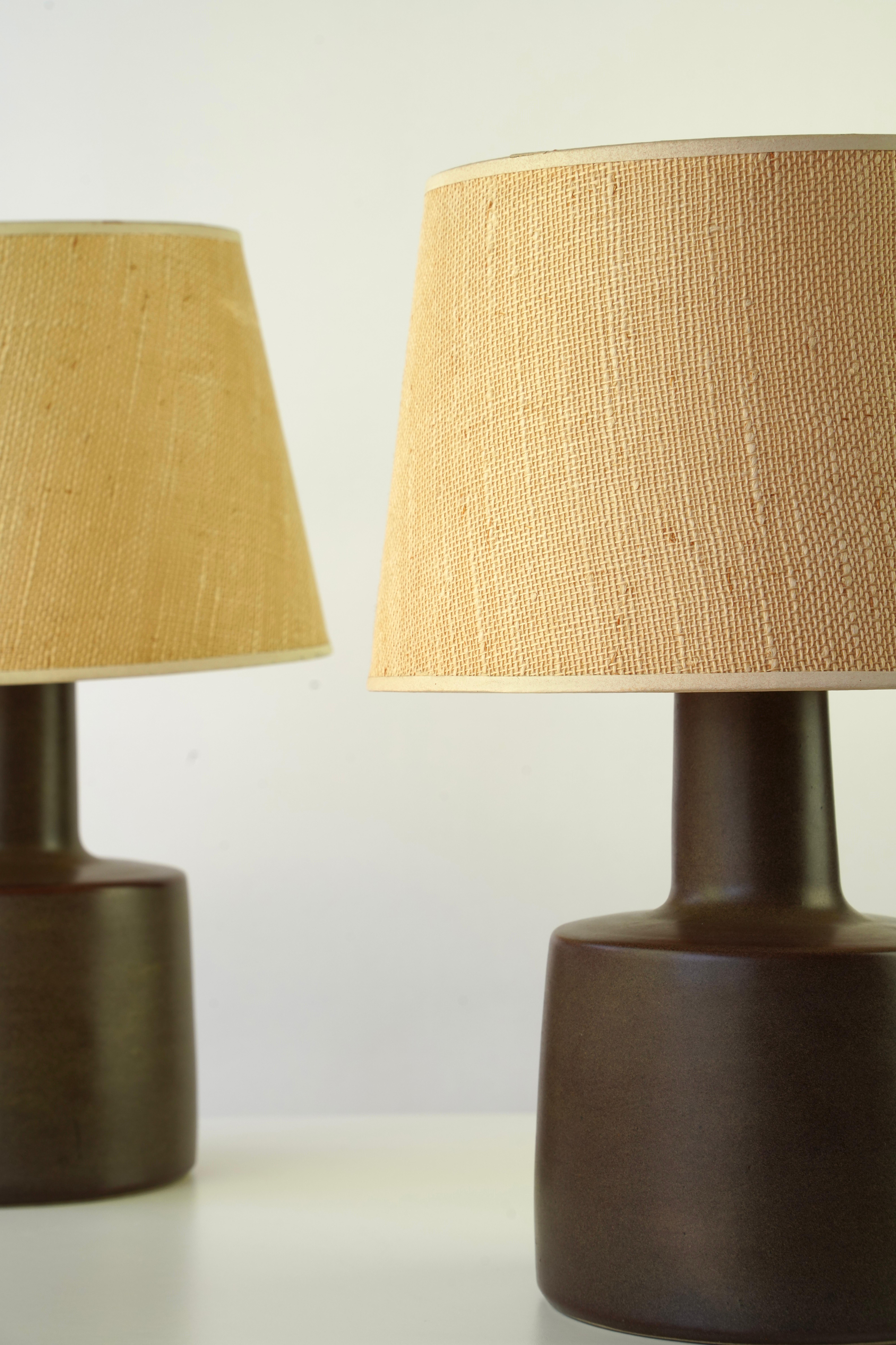 Pair of Stoneware Lamps by Jane & Gordan Martz for Marshall Studios, Inc
Circa 1950s

Featured in Fall Catalog No. 4 Dated 1953

Lamp 105-30-S1
Dark Brown Matte Glaze 
Original Clip Shade in Tan Burlap

Sold as Pair