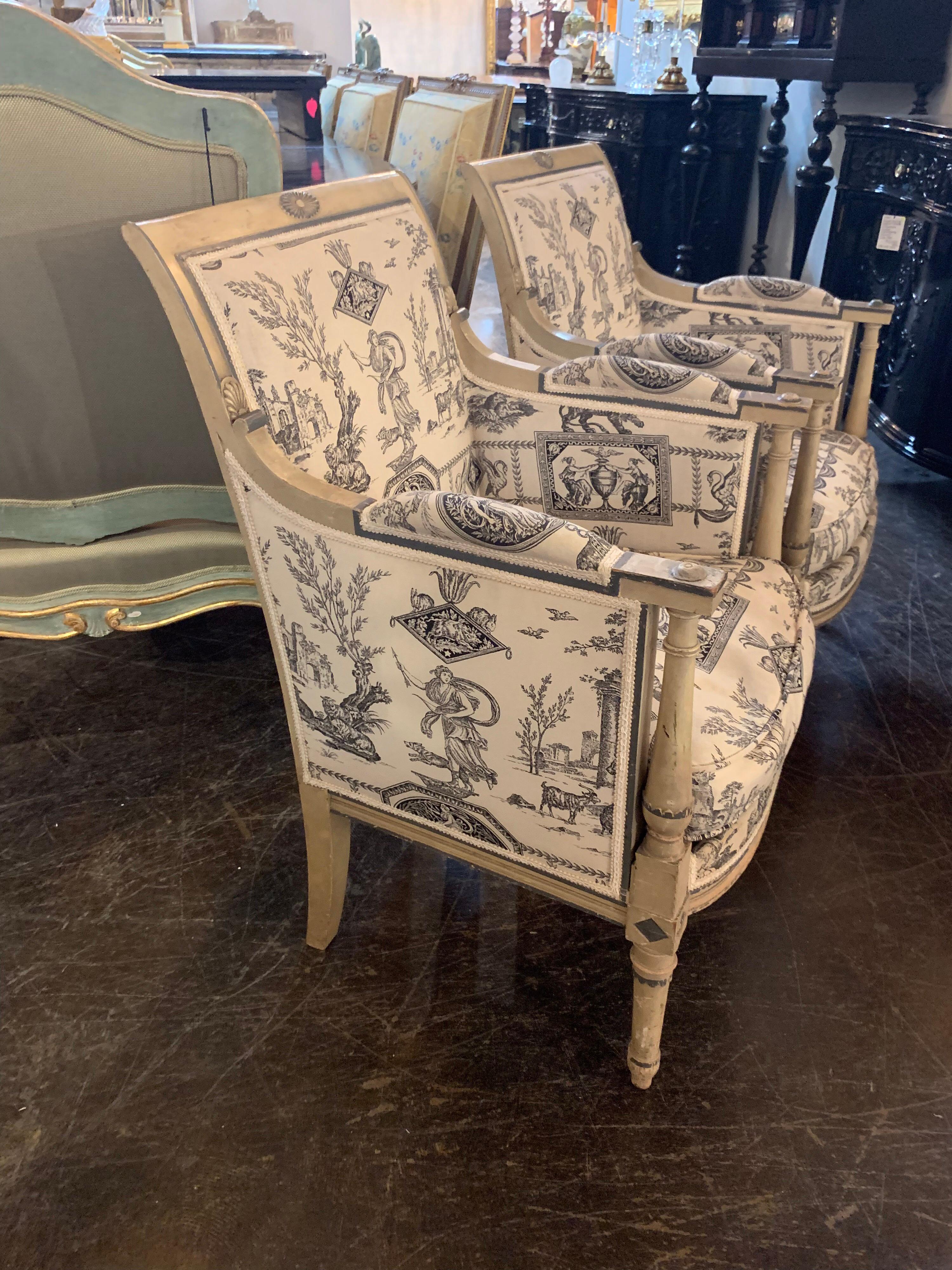 Raffinata coppia di poltrone Jansen Directoire STAMPED. Il legno presenta intagli ed è dipinto con una bella patina color crema con dettagli verdi lungo i bordi del legno. Le sedie sono rivestite con un interessante motivo neoclassico color crema e
