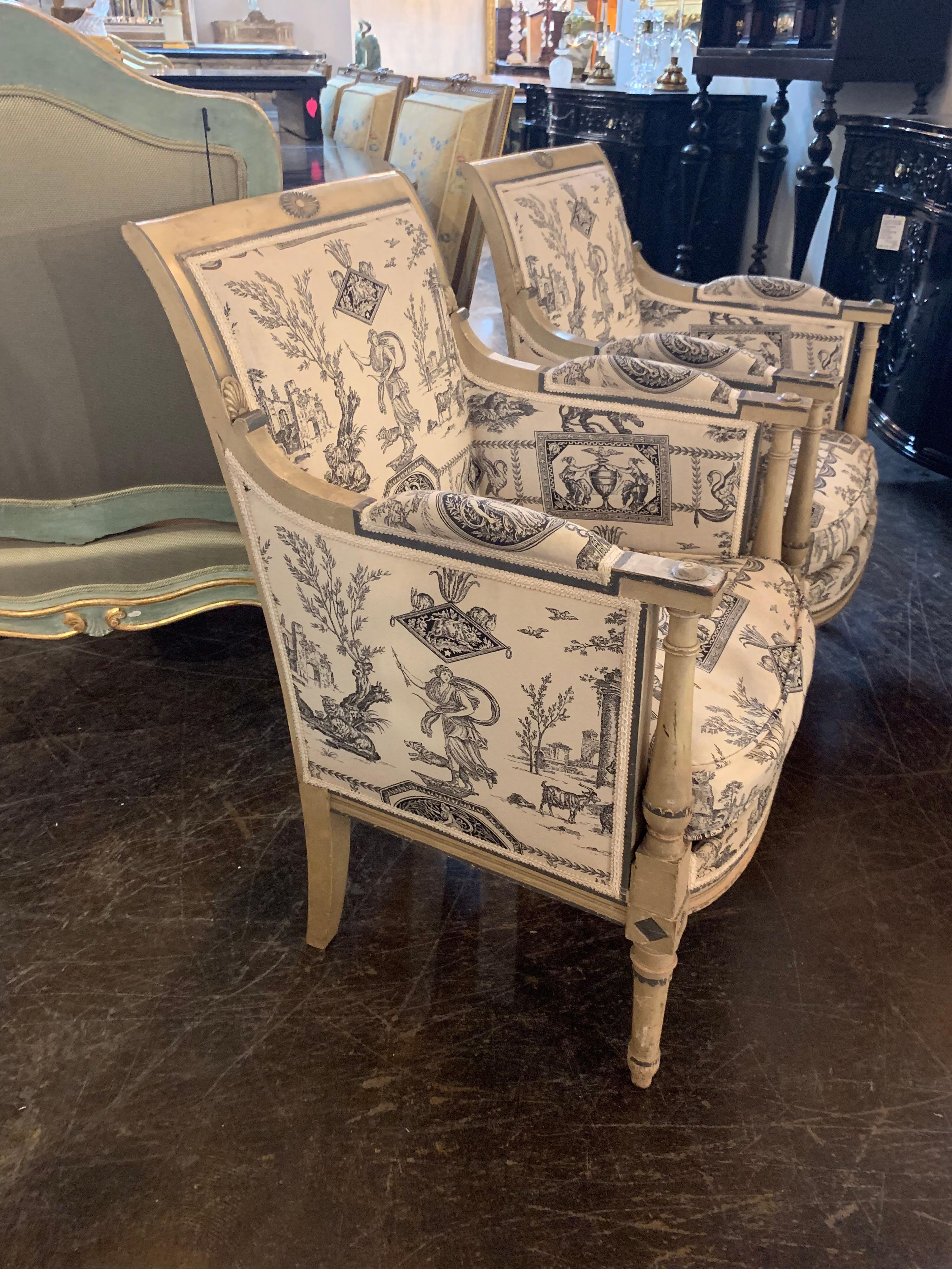 Fine pair of STAMPED Jansen Directoire' armchairs. The wood has carvings and are painted in beautiful crème patina with green details along the borders of the wood. The chairs are upholstered in an interesting crème and black neoclassical pattern.