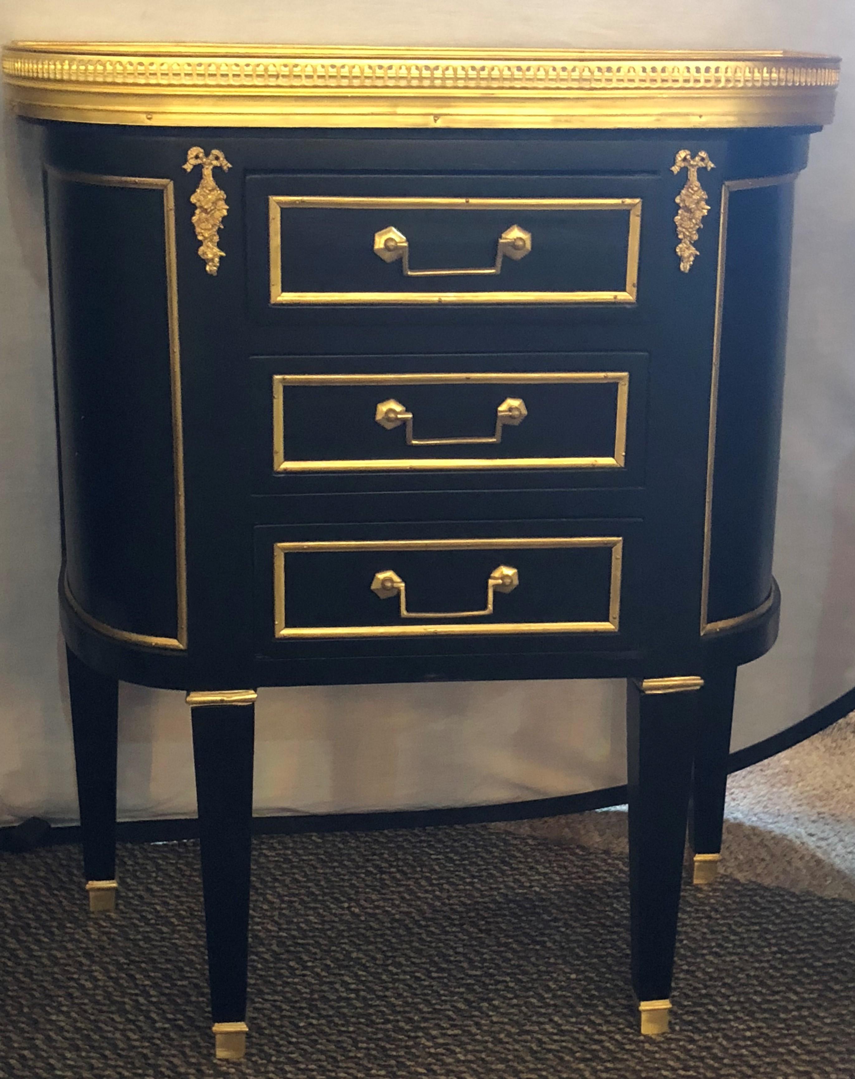 Pair of Jansen inspired marble-top galleried ebonized end tables with three drawers. These Hollywood Regency end tables will shine next to any bed or sofa and can surely sit on their own in most room settings. The rounded sides and flat fronts are