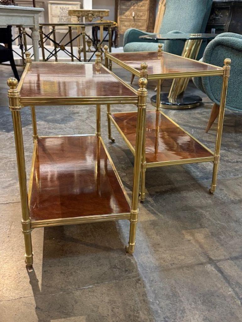 The Pair of Jansen Manner Mahogany and Brass Side Tables. The combination of the rich mahogany wood and brass accents gives them a luxurious look that is sure to add a touch of sophistication to your home decor. Perfect for serving as functional