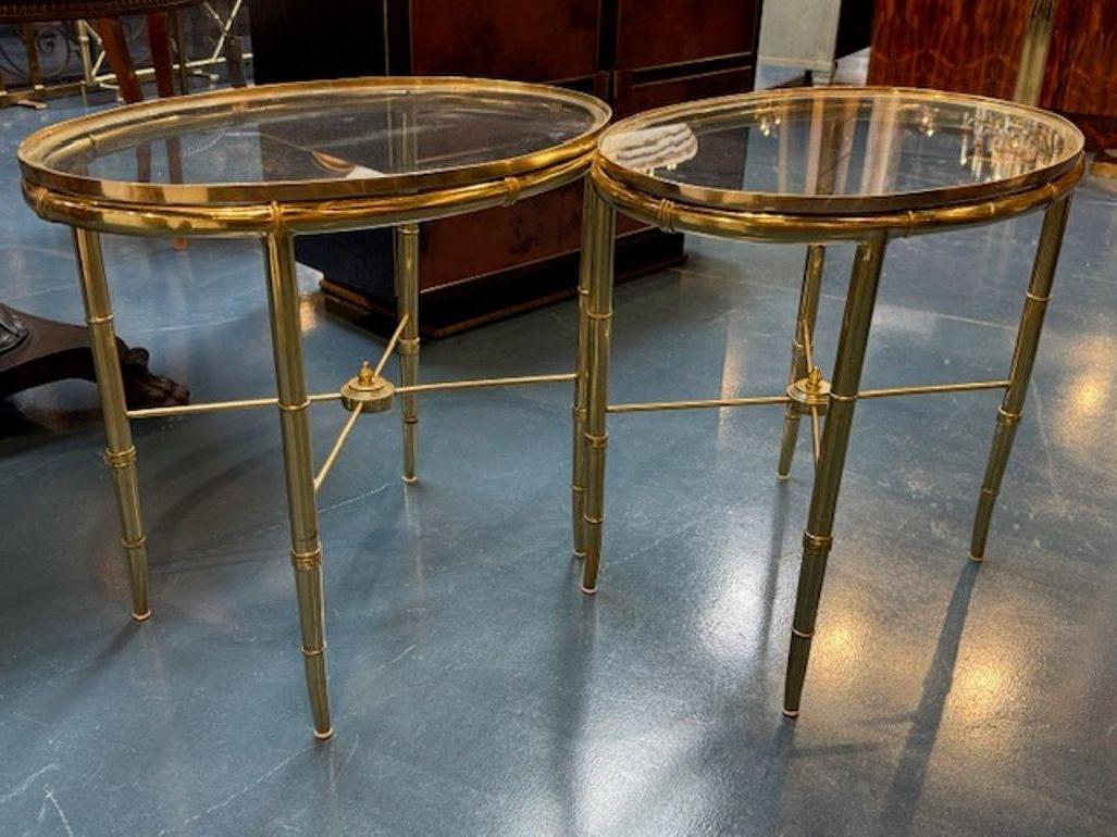 This product is a pair of Jansen style brass bamboo form and glass side tables, embodying a Mid-Century Modern style design. These elegant tables are perfect for adult use in a living room or home office setting. The combination materials creates a