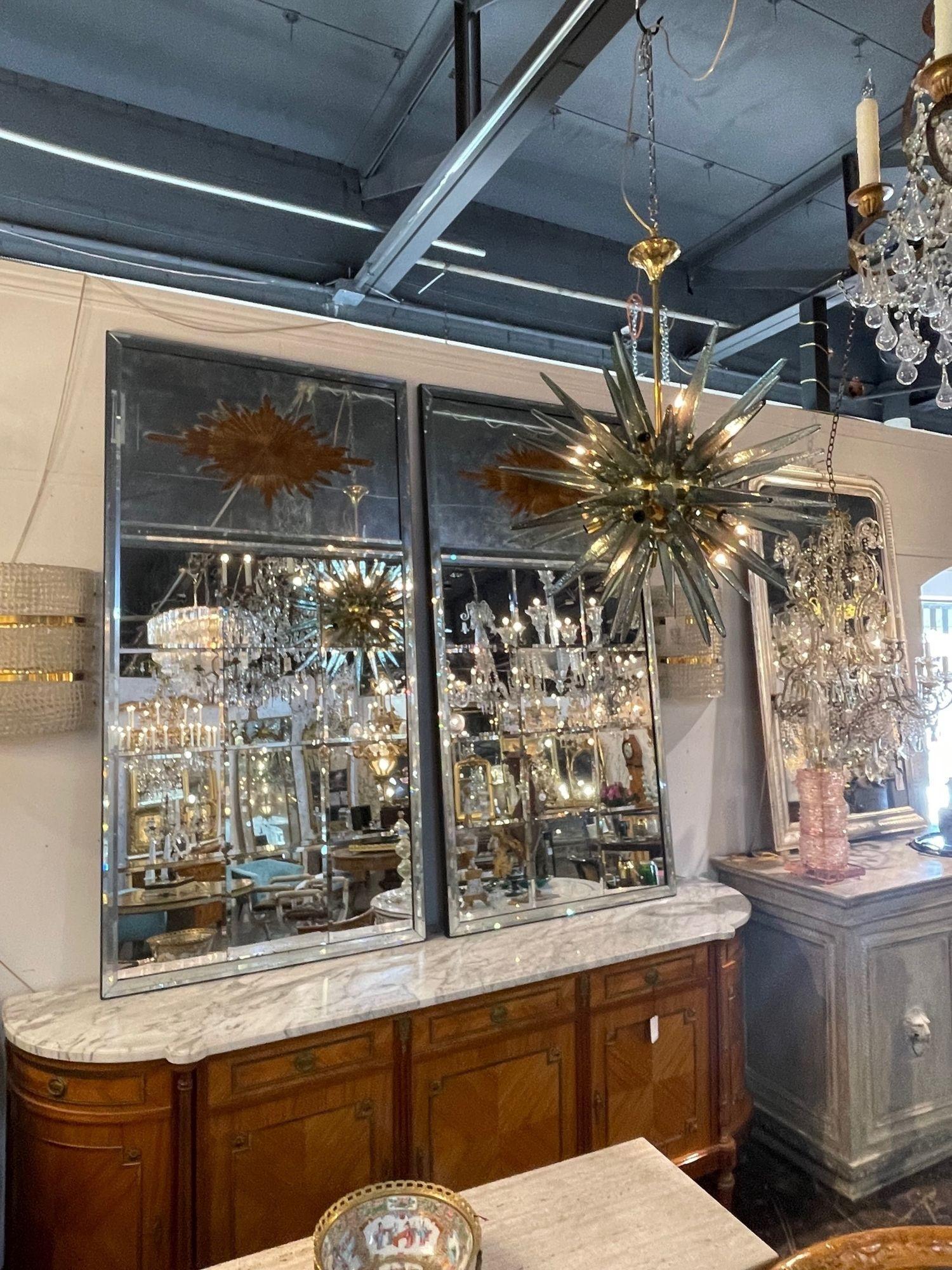 Gorgeous large scale pair of French Jansen style Eglomise sunburst Trumeau mirrors with beveled glass. This beautiful technique gives these a lot of depth. A stylish pair that creates a huge impact! Amazing!