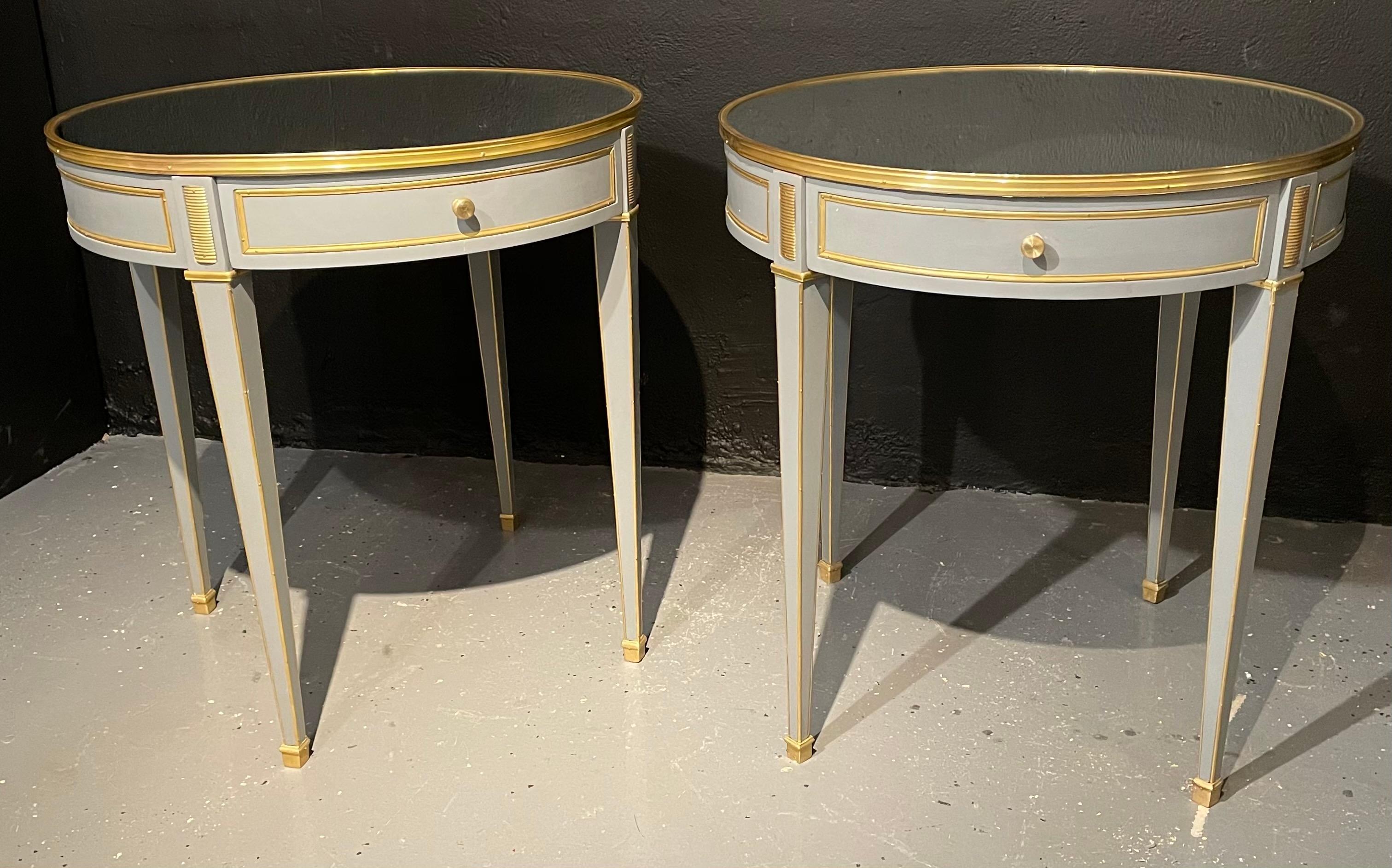 Pair of Jansen style painted end or lamp tables. Bouilliote Form. These simply stunning sleek and stylish end tables have bronze galleried mirrored tops supported by a Louis XVI style case housing one drawer. The apron having bronze framing all