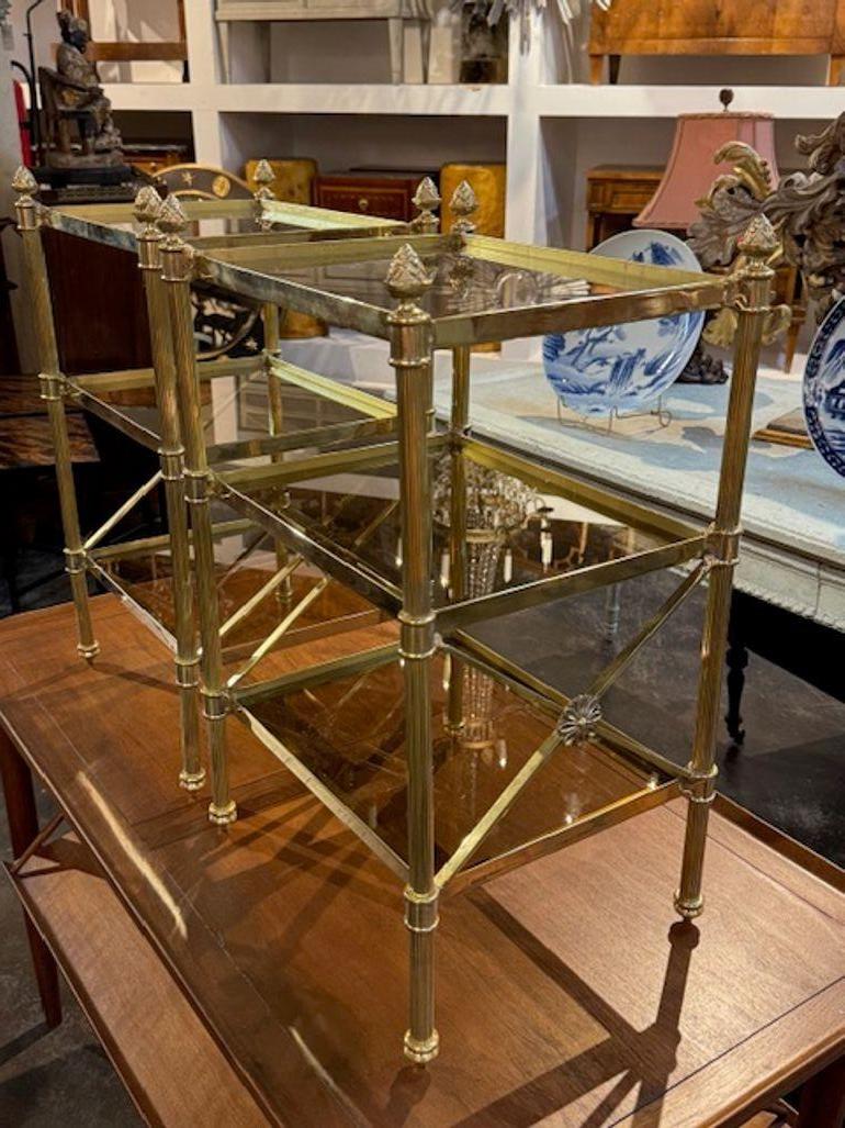 This product is a pair of Jansen style polished brass side tables, featuring a 3 tier modern design. The classic style design with the nice brass finish and glass adds a touch of elegance and sophistication to any room. Perfect for adding a stylish