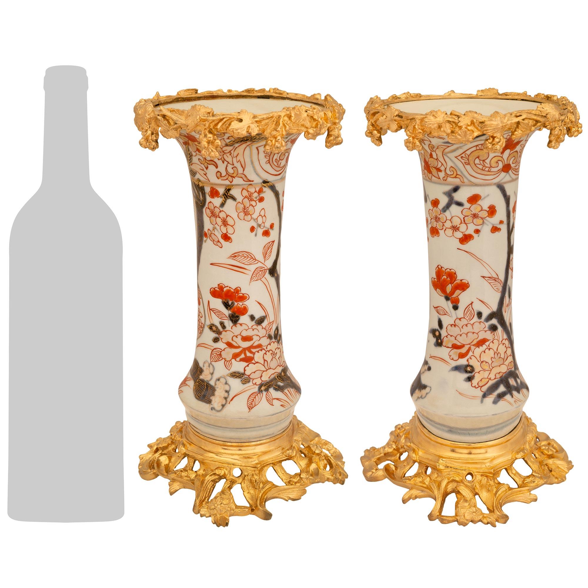 Una sensazionale ed elegante coppia di vasi giapponesi del XIX secolo in Imari Porcelain e francesi Luigi XV in Ormolu. Ogni vaso colorato è sollevato da una base in Ormolu traforata con una fascia circolare superiore screziata e sostenuta da