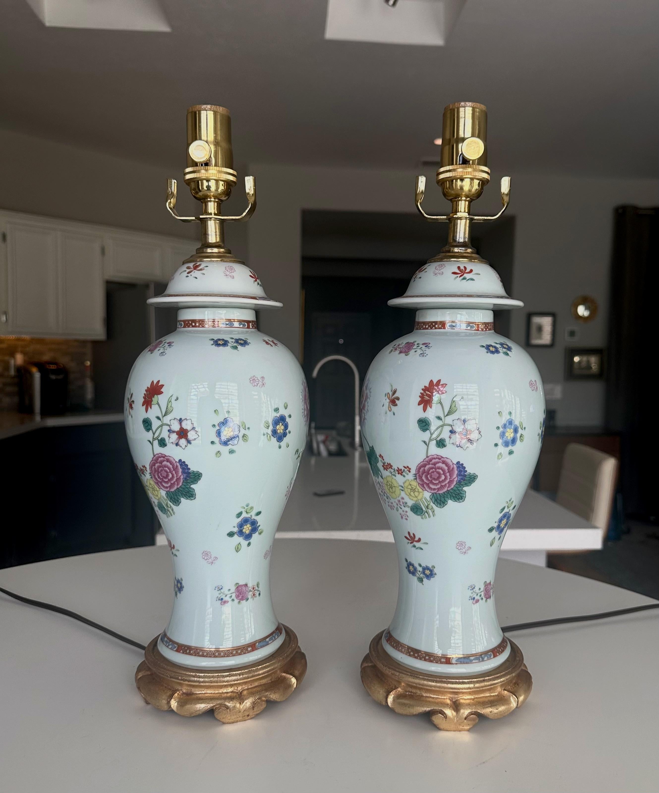 Paire de vases japonais à motifs floraux peints à la main et de petite taille, montés sur des bases de lampe en bois tourné et doré. Les deux vases sont estampillés 