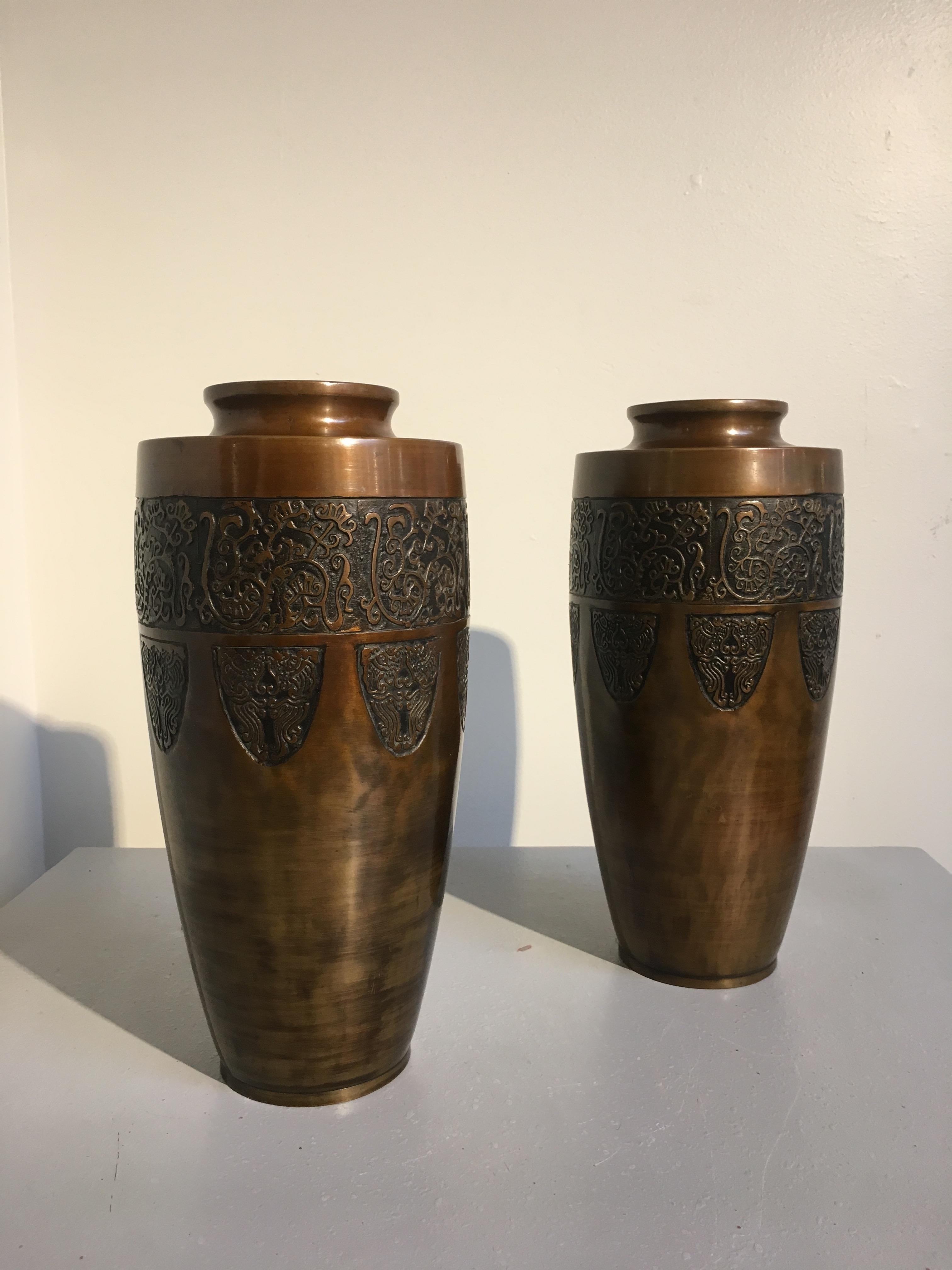 A handsome pair of Japanese Art Deco cast and patinated bronze vases, Taisho Period, 1920's, signed.
The heavy vases of slender ovoid form, with flat shoulders and short necks with everted rims. The tall bodies tapering slightly. Each vase