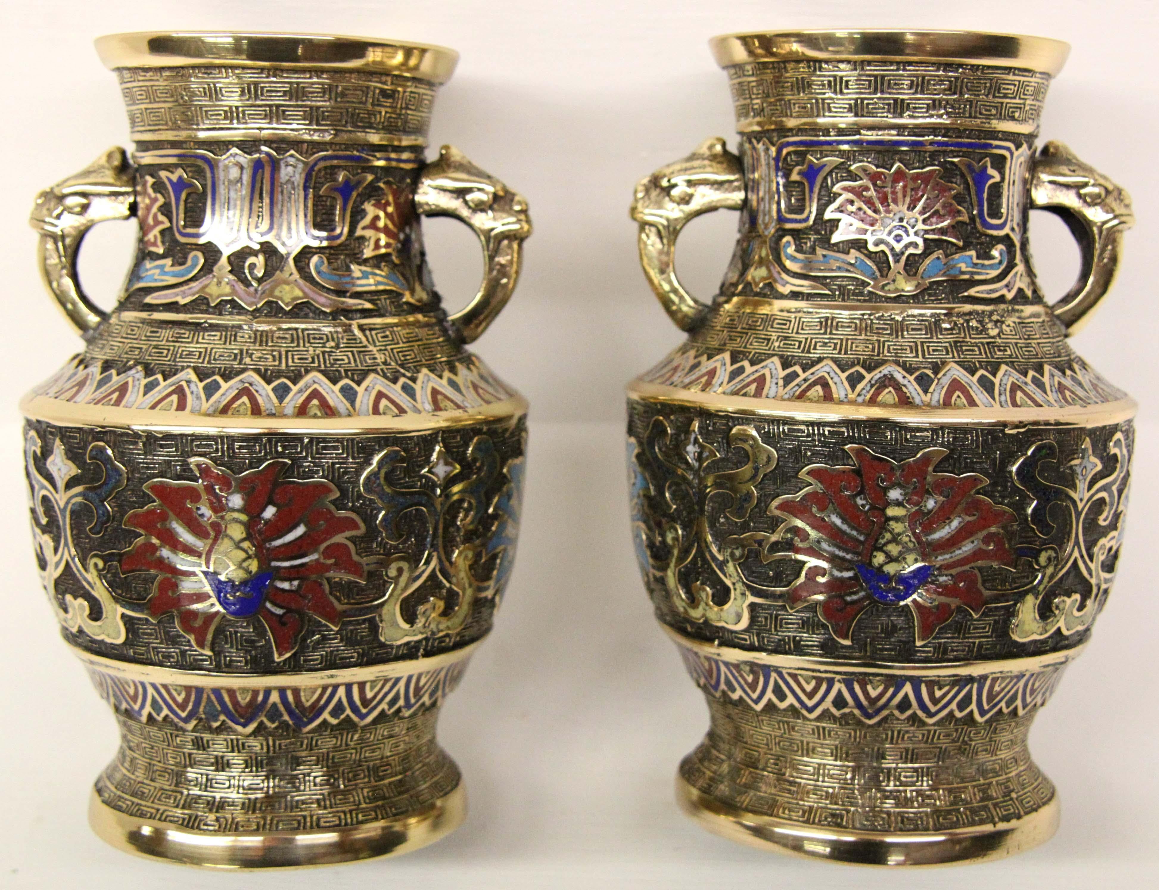 Pair of Japanese brass and enamel Champleve vases, with handles on either side, red and blue enamel inset in different designs.