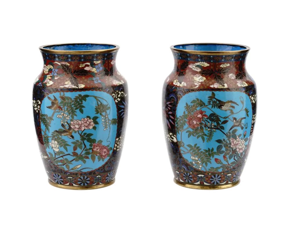 A pair of high quality Japanese, Meiji era, enamel over brass vases. Each vase has an amphora shaped body and a short wide neck. Each ware is enameled with polychrome medallions depicting birds and butterflies in blossoming flowers, and images of