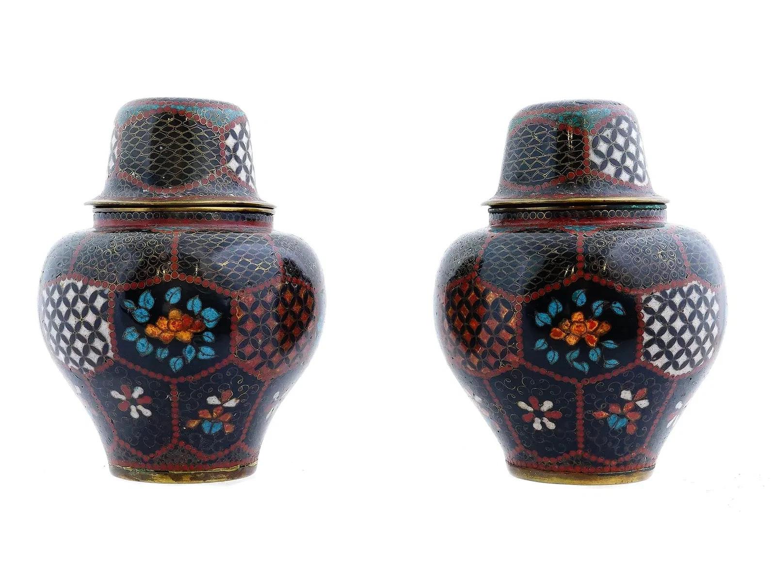 Un par de jarras japonesas esmaltadas sobre cobre dorado. El exterior de las jarras está adornado con medallones de esmalte policromado que representan ornamentos florales, de follaje, geométricos y volutas foliadas, realizados con la técnica