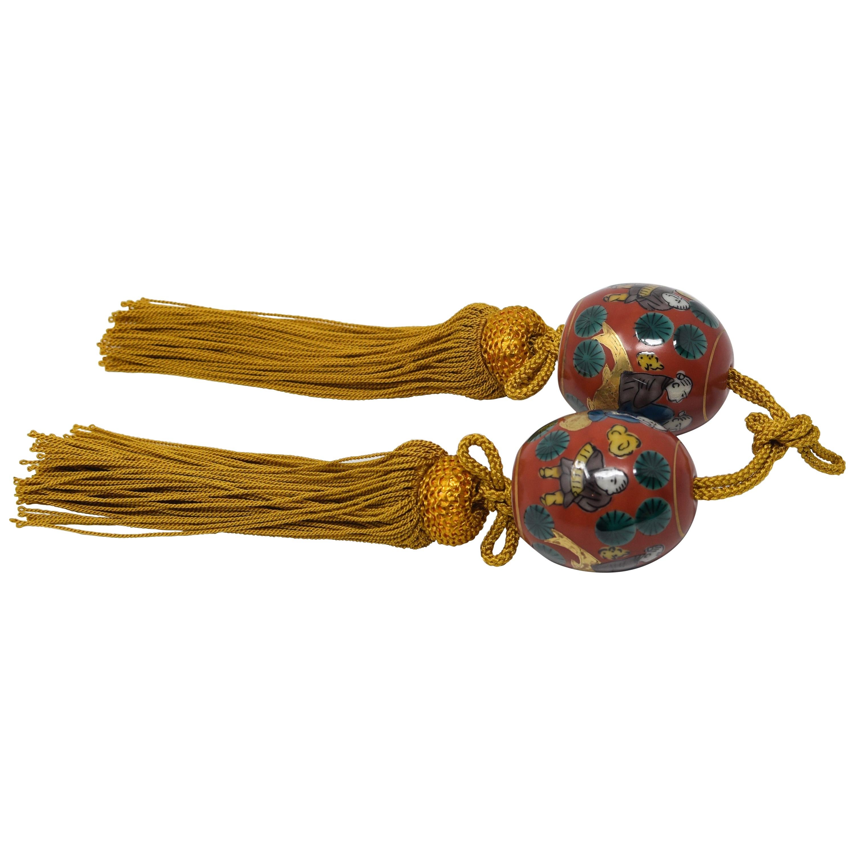 Paire de porcelaines japonaises rouges, vertes et dorées à poids en volute