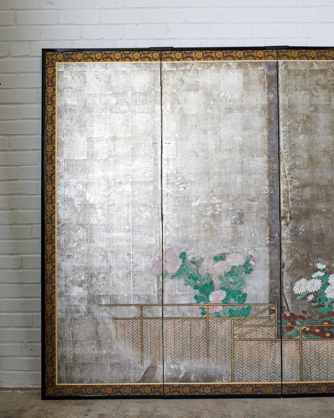 Remarkable pair of early 19th century Japanese late Edo period screens depicting summer chrysanthemums growing along a brushwood fence. Ink and color pigments over a dramatic silver leaf ground. Kano school influence with moriage flowers. The love