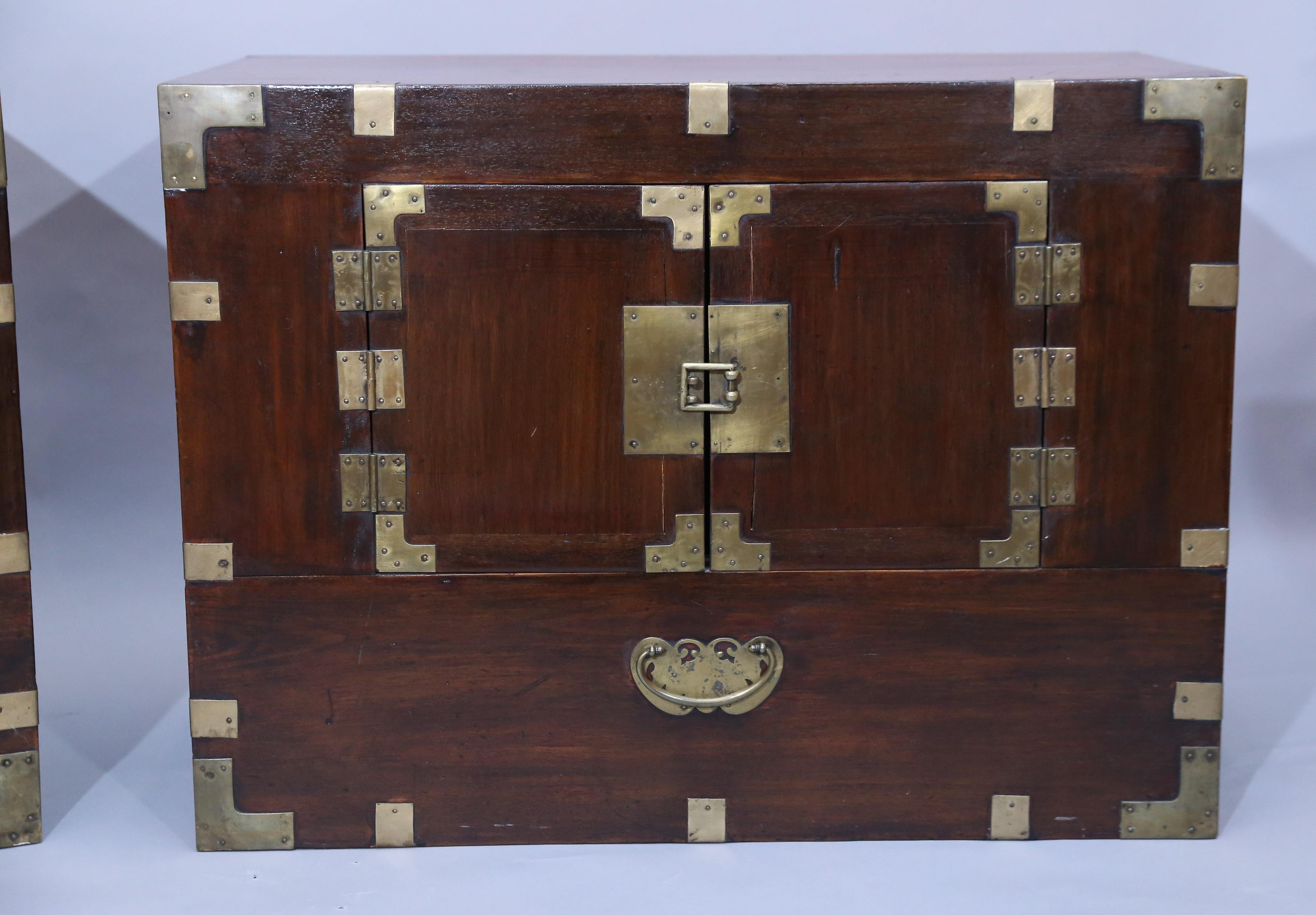 Matching pair of Japanese pine Tansu chests feature Brass hardware.
Front features a pair of doors and a faux drawer.

This pair is ideal for a pair of nightstands or stacked for a
cabinet.