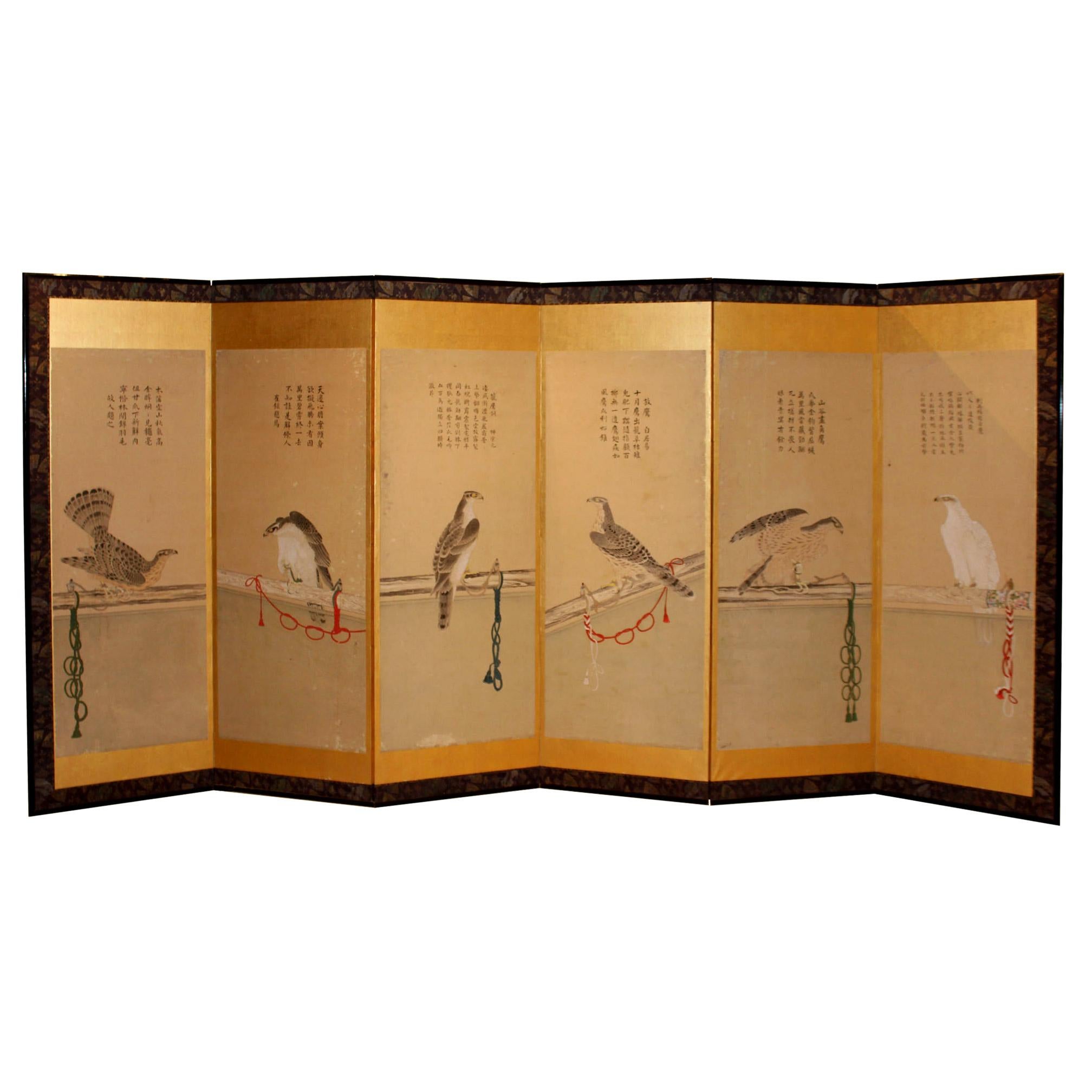 Antique pair of six-panel Japanese screen depicting hunting hawks with colorful tethers. Ink and color on rice paper with gold leaf surround and silk brocade border. Remounted on gold leaf with original wood frame. Meiji period, circa 1885. Kyoto,