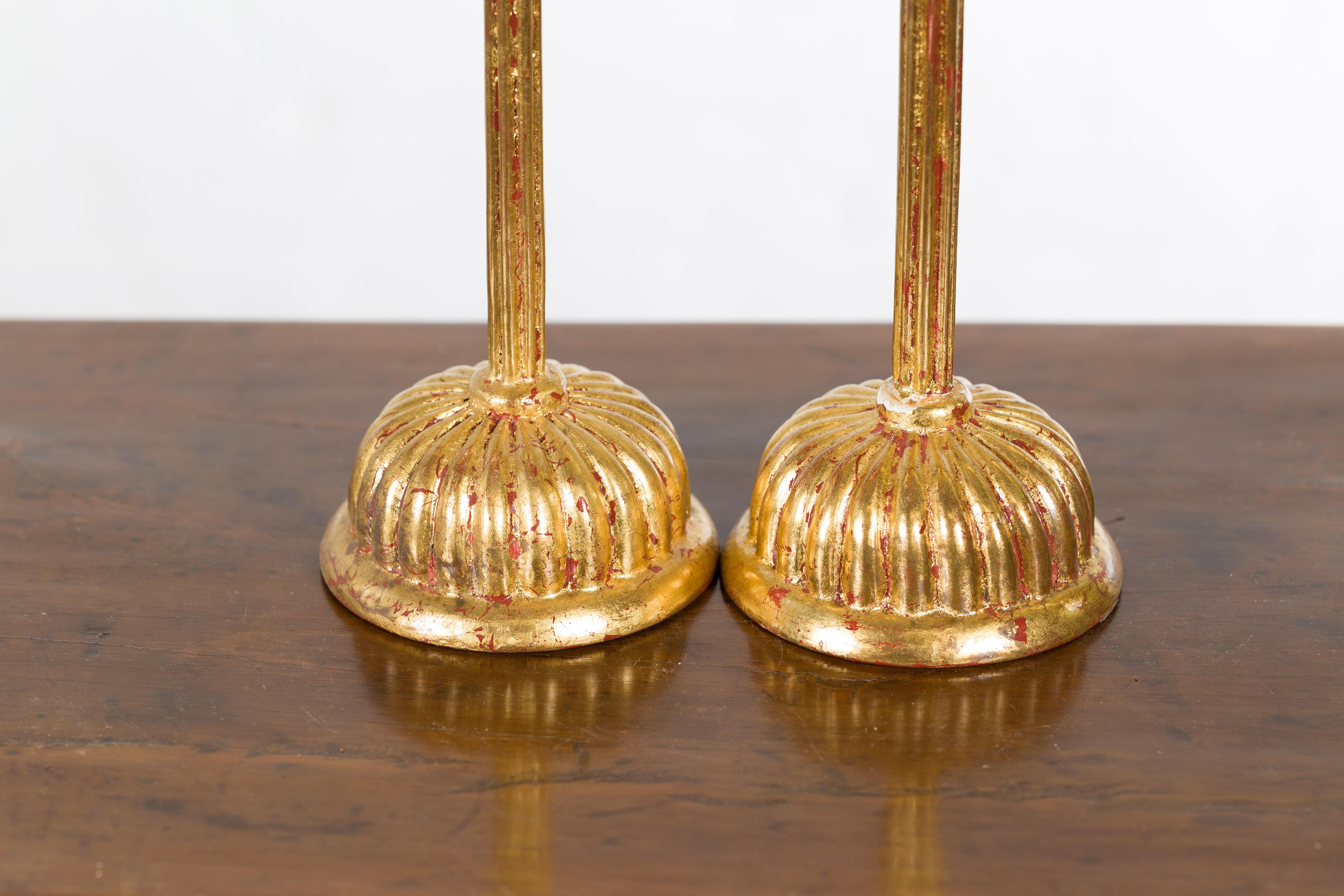 A pair of Japanese vintage gold lacquered candleholders from the mid 20th century with lotus bobèches from a Hinamatsuri set. Created in Japan during the midcentury period, each of this pair of candleholders features a lotus shaped bobèche sitting