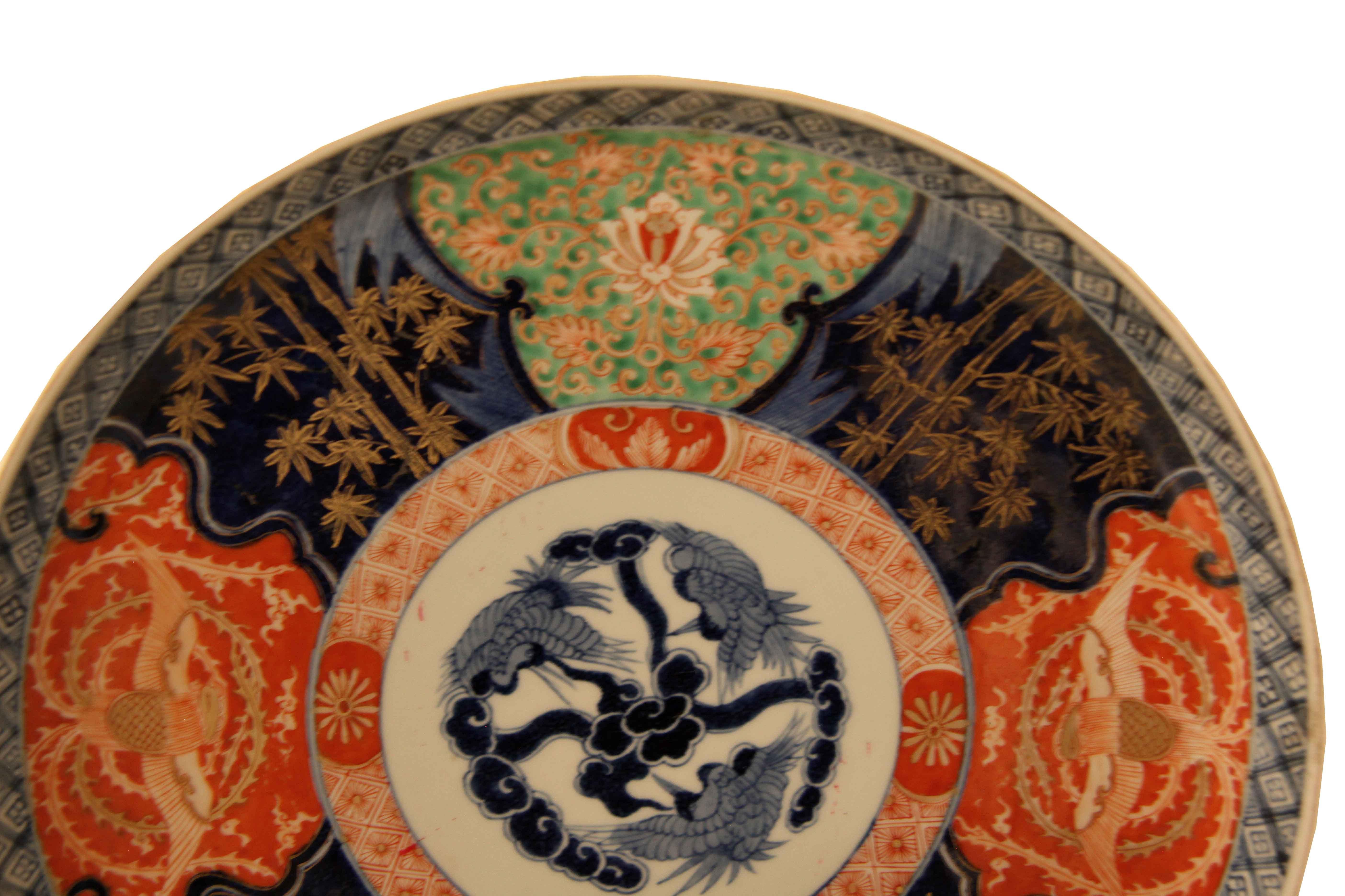 Pair of Japanese Imari chargers, the outer border to the rim is a narrow crosshatch of blue and white lines;  inner border is alternating cartouches with birds, flowers and bamboo in typical Imari colors; the center features three birds with wings