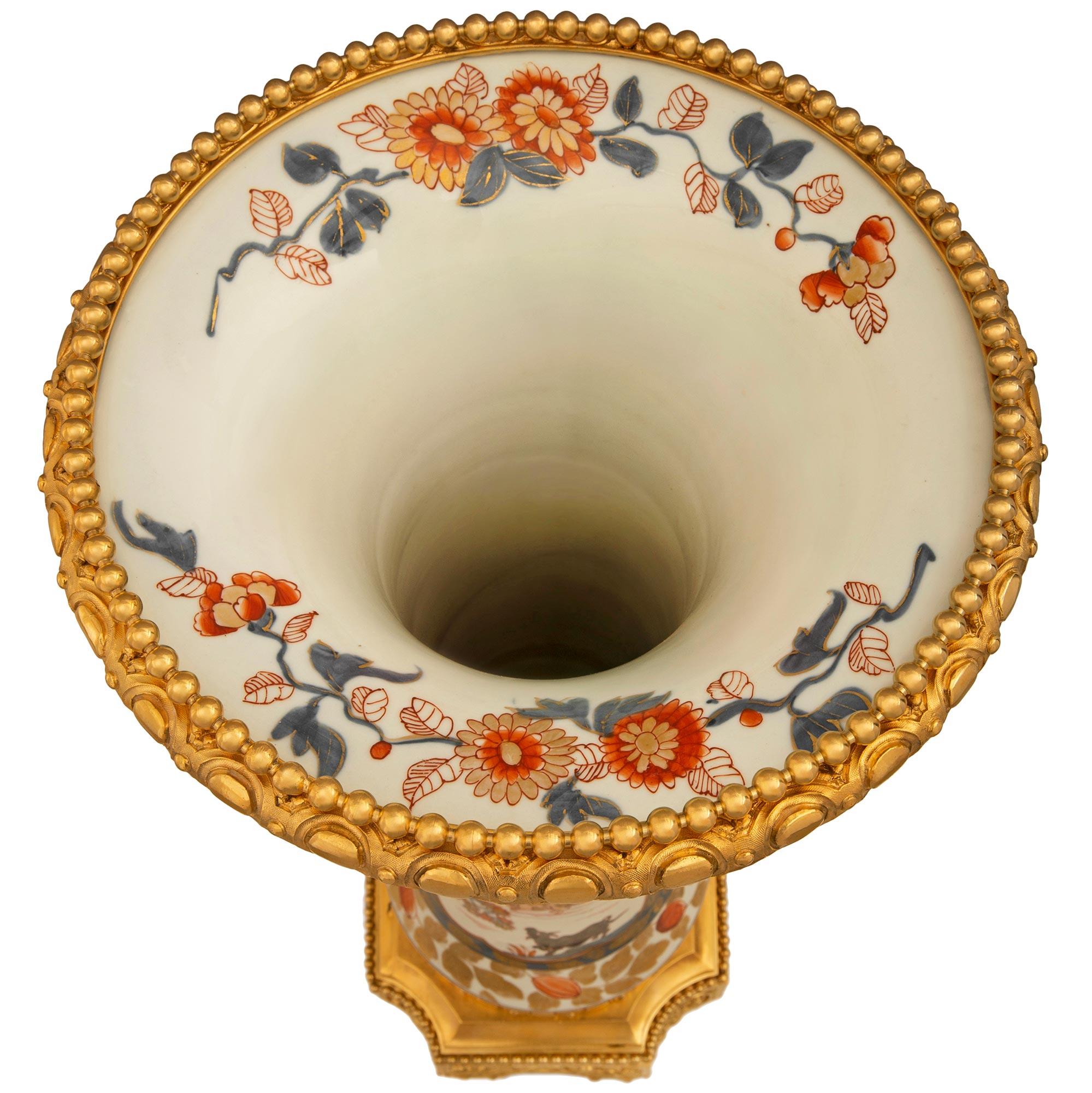 A sensational and large scaled pair of Japanese 19th century Imari porcelain and French 19th century Louis XVI st. Ormolu mounted vases. The pair of vases are raised by square Ormolu bases with concave corners. Each side of the bases have recessed