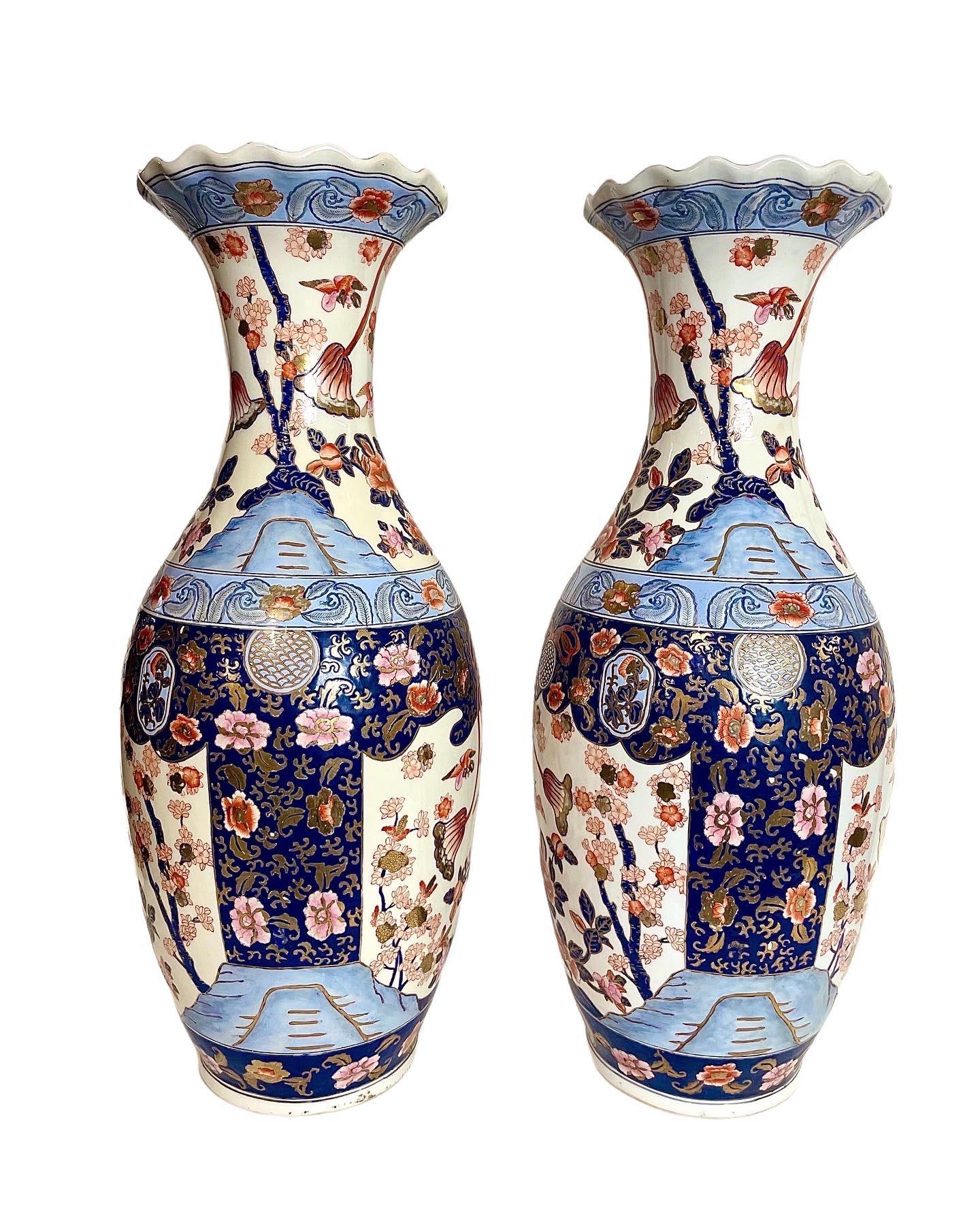 An impressive pair of antique Japanese Imari vases, dating from the start of the 20th century.  With a decor of birds, blossoms and foliage in shades of iron red, navy, and delicate pinks and blues, the design is highlighted with applied gilt and