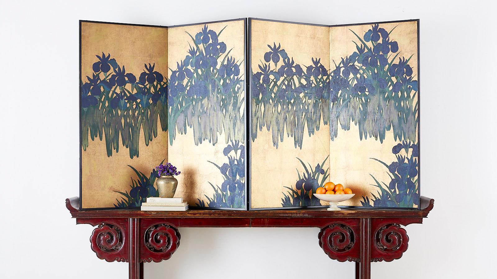 Dramatic pair of Japanese two-panel screens depicting Kakitsubata or flowering Irises on a gilt gold leaf background after Ogata Korin (Japanese 1658-1716). The screens feature abstracted blue Japanese irises in bloom with green foliage having a