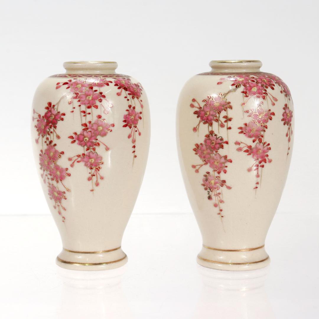A fine pair of vintage Japanese Satsuma miniature vases.

By Koshida.

Each vase with a cream ground with pink wisteria flower decoration, red accents and gilt highlights. 

The rim and footrim are gilt, and the opening of each vase is surrounded by