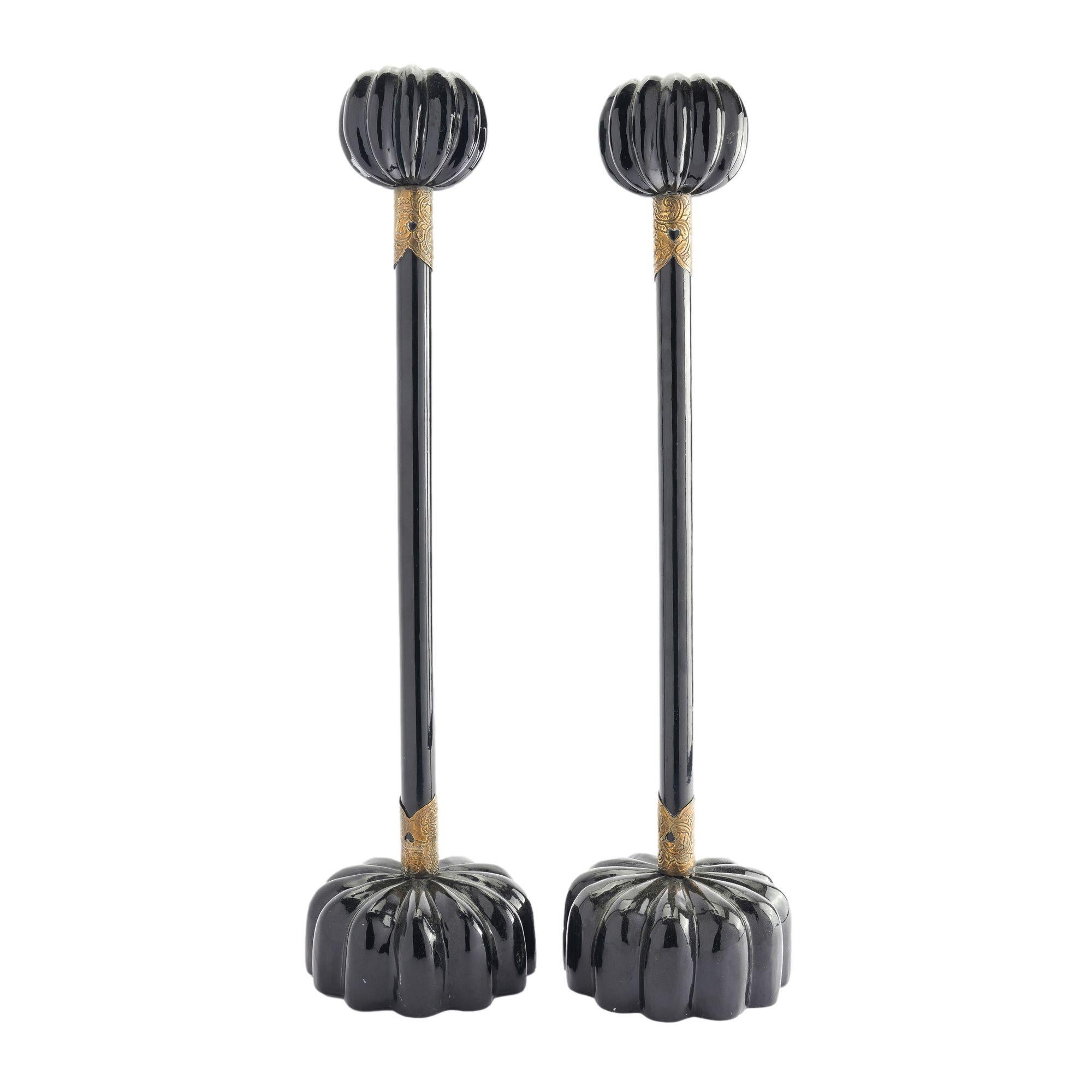 Pair of Japanese wood altar sticks with black urushi lacquer, melon carved bases, rods with engraved brass embellishments, and a melon carved candle cup.

Japanese, Meiji Period, 1850-1900.