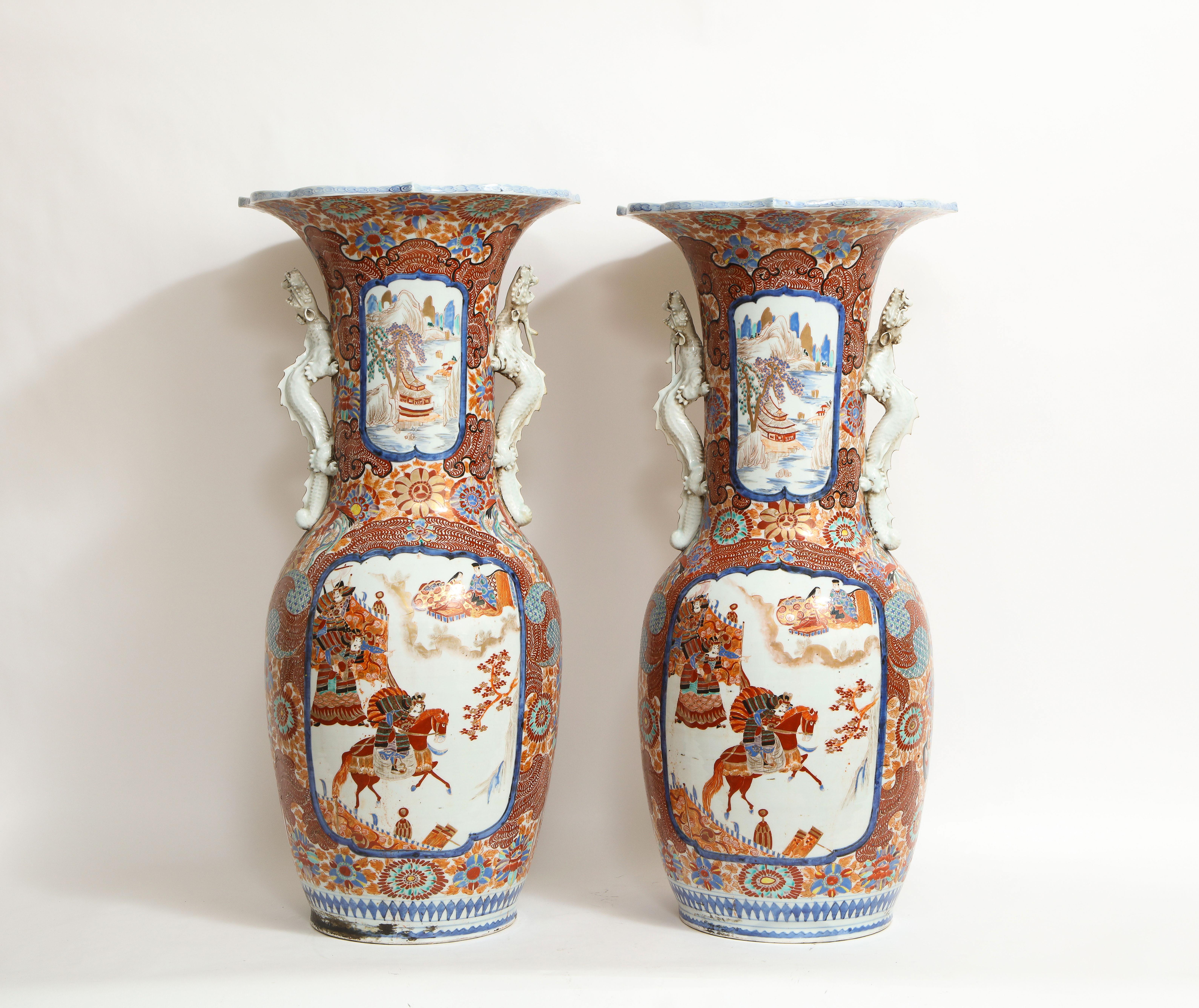 A Monumental pair of Japanese Meiji Period Imari vases with Dragon handles, Japanese Porcelain Studio Marks on Underside. Each is beautifully hand-painted with fantastic Imari decoration. The vases consist of panels of underglaze blue borders with