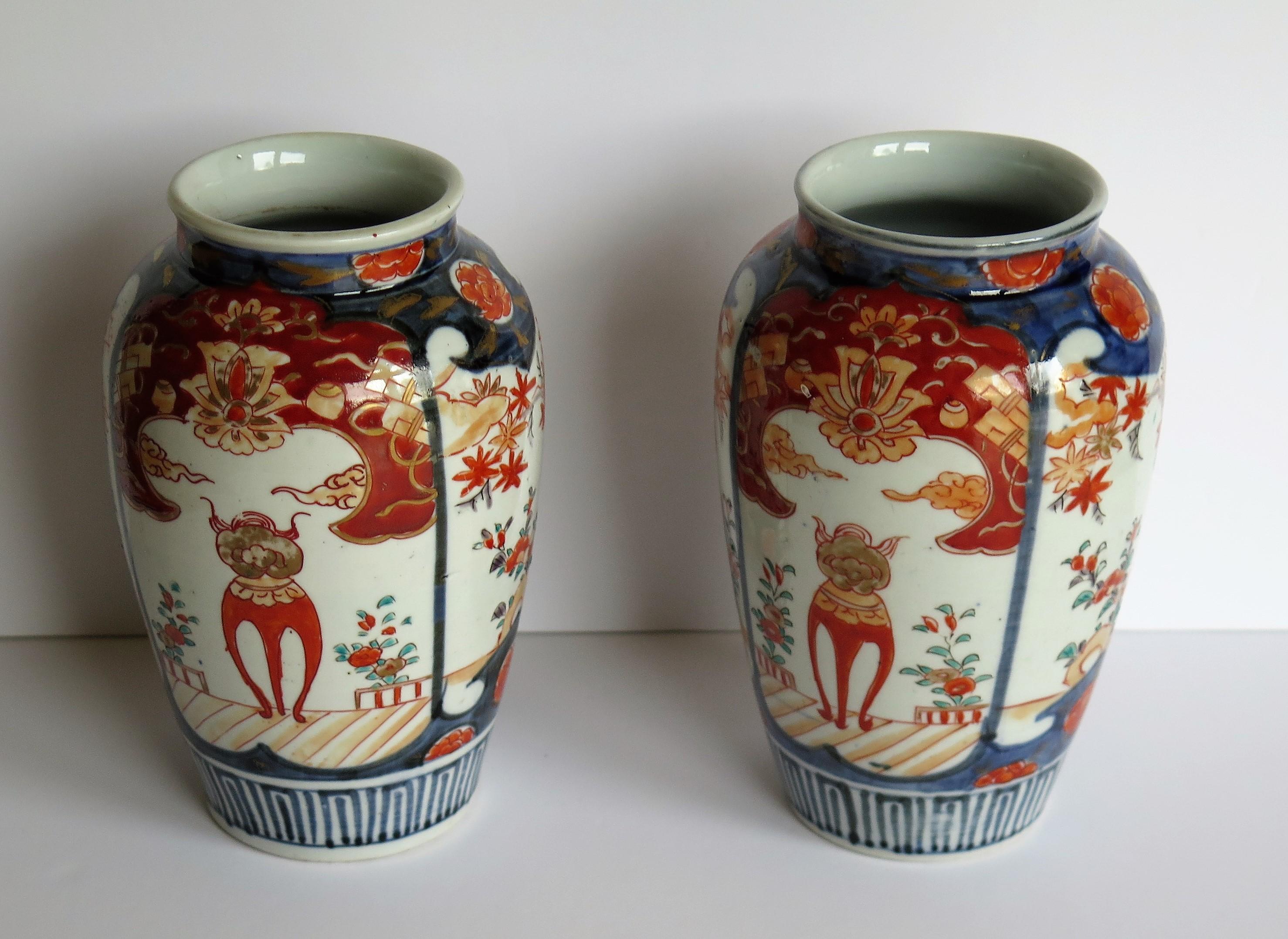 These are a good quality pair of very decorative gilded hand enameled Japanese porcelain vases which we date to the Meiji period of the 19th century, circa 1880.

Each vase has a baluster open necked shape and has been hand painted in an Imari