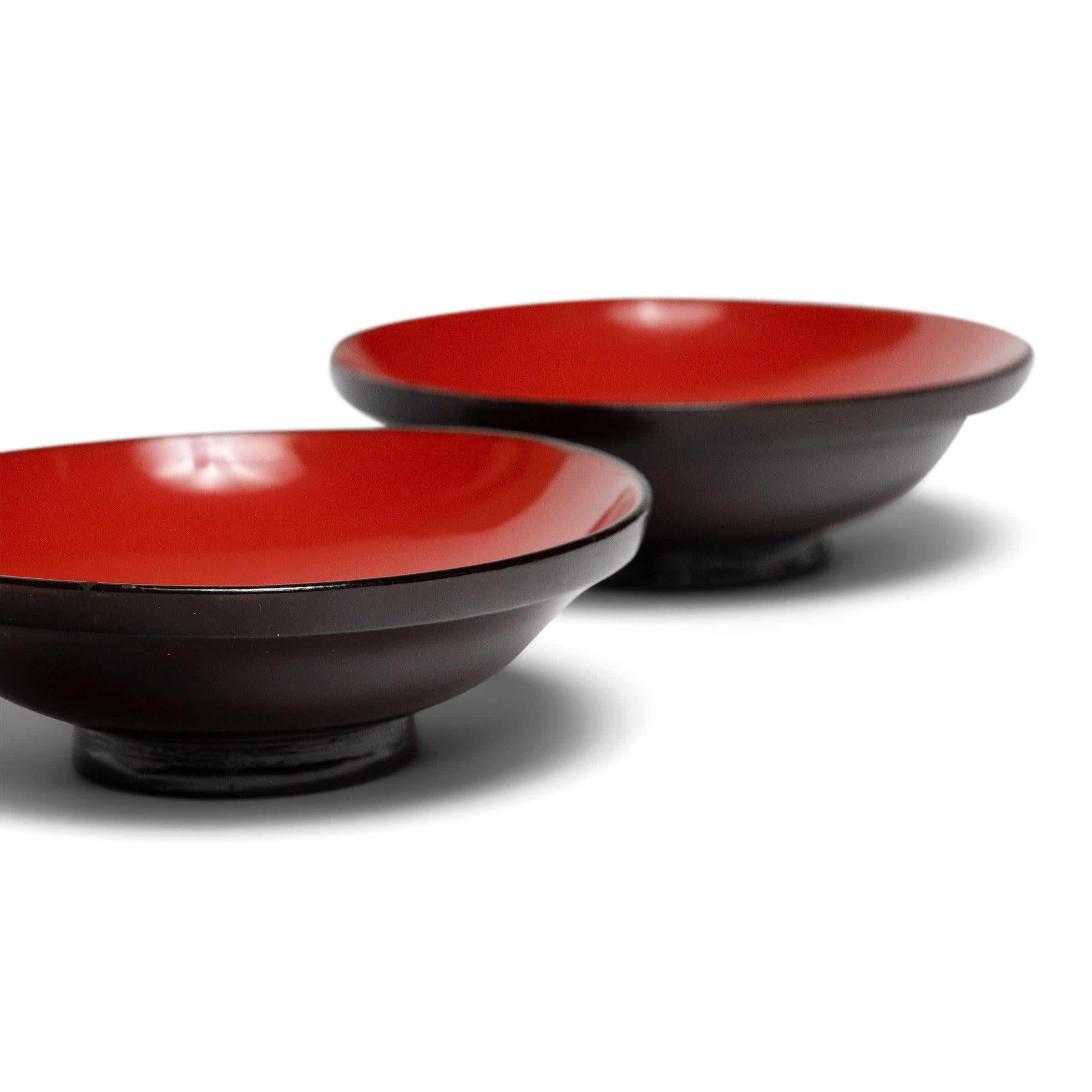 Ligeros y compactos, este par de cuencos pequeños son un ejemplo de la clásica vajilla japonesa lacada que se utiliza a diario para comer y beber. Cada cuenco tiene una silueta sencilla, formada por un interior liso y curvado, un exterior curvado en