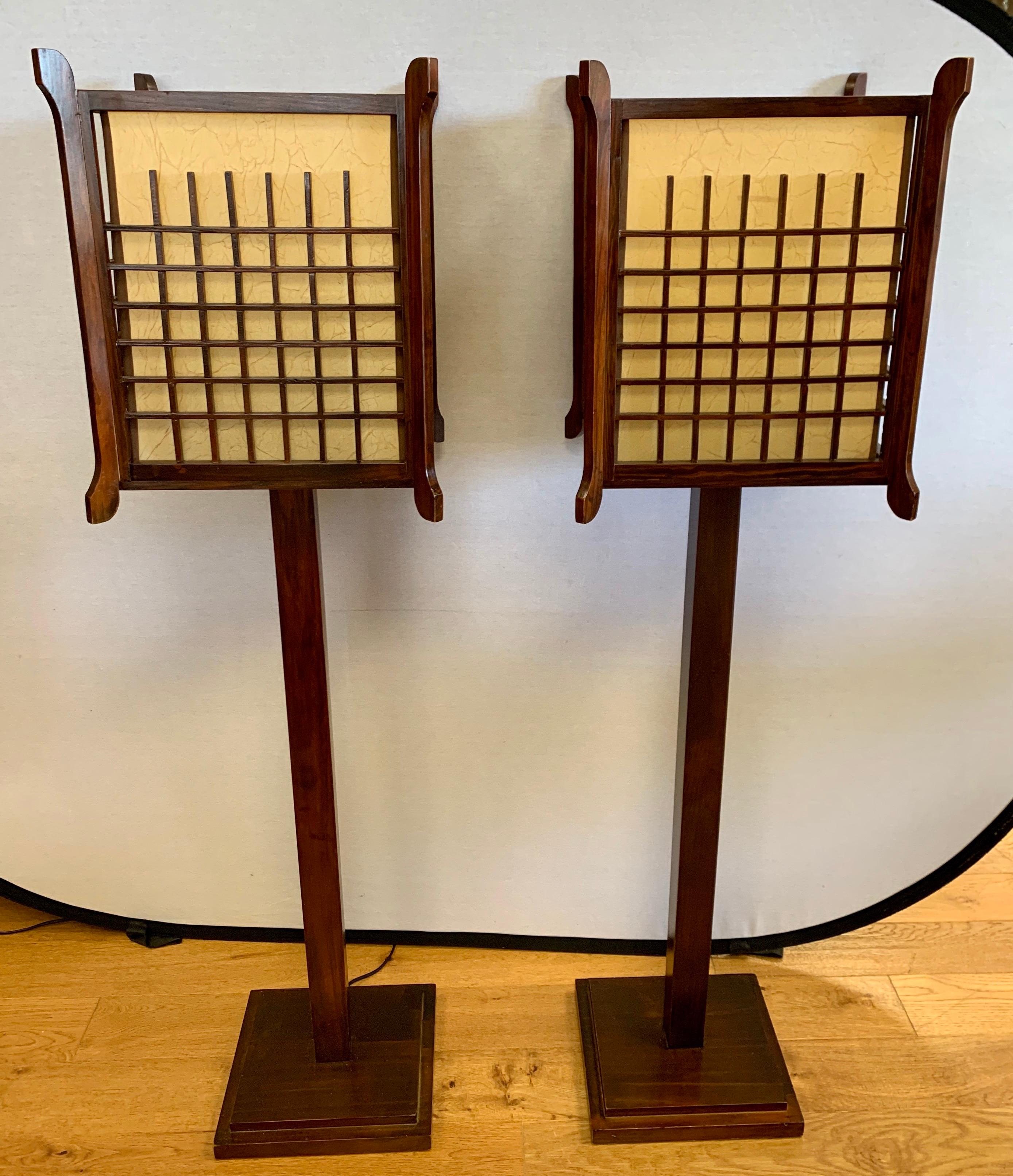 Stunning pair of Japanese style tall floor lamps in a mahogany finish with intricate geometric lattice
work over rice paper. Not your run of the mill reproduction. Vintage and real wood. The scale is perfect
and the modern lines allow them to