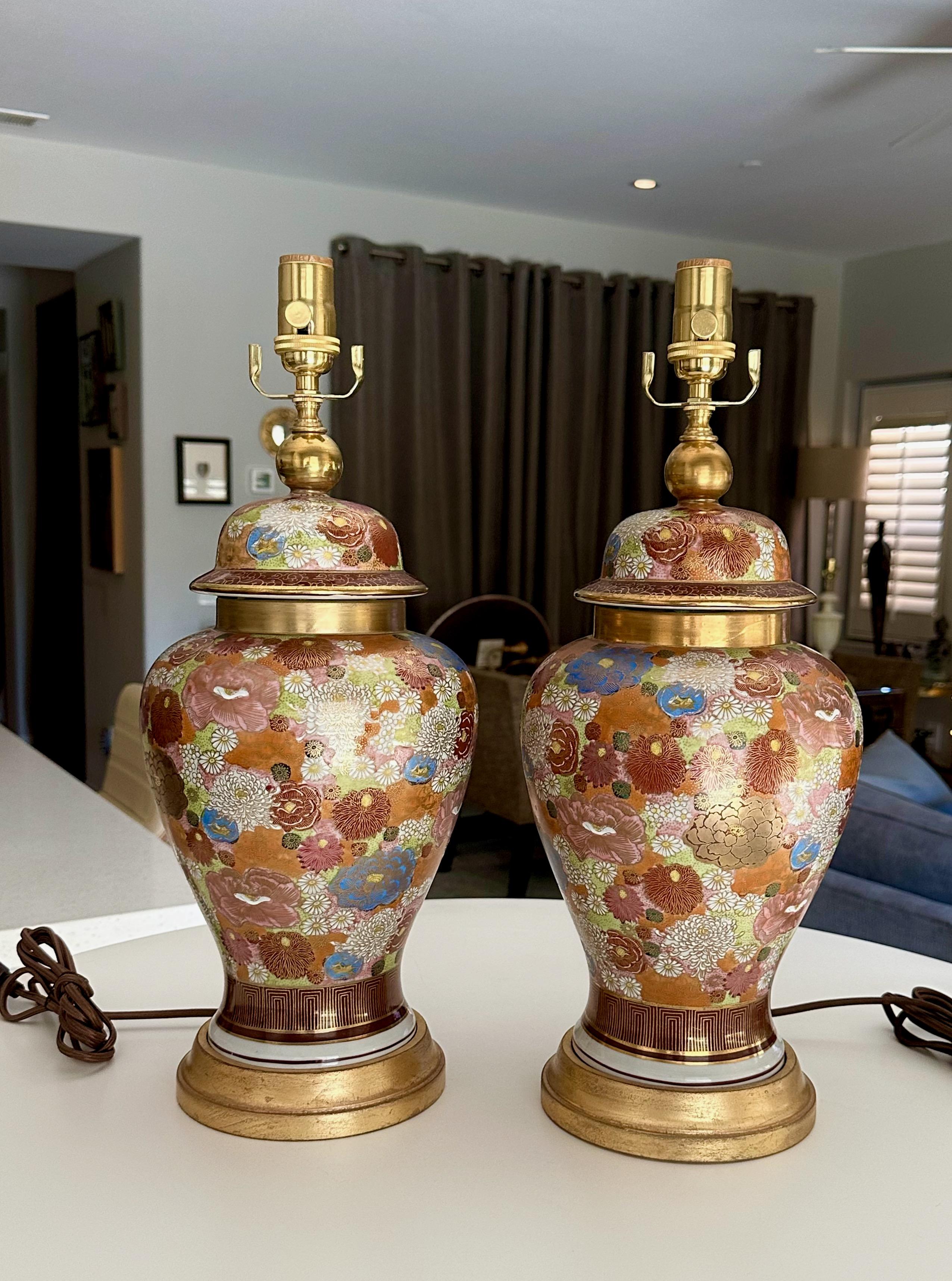 Paire de vases à gingembre à couvercle de Satsuma, peints à la main et à motif floral, montés sur des pieds de lampe en bois tourné et doré. Les vases sont peints de manière experte avec différentes fleurs dans un éventail de couleurs riches.