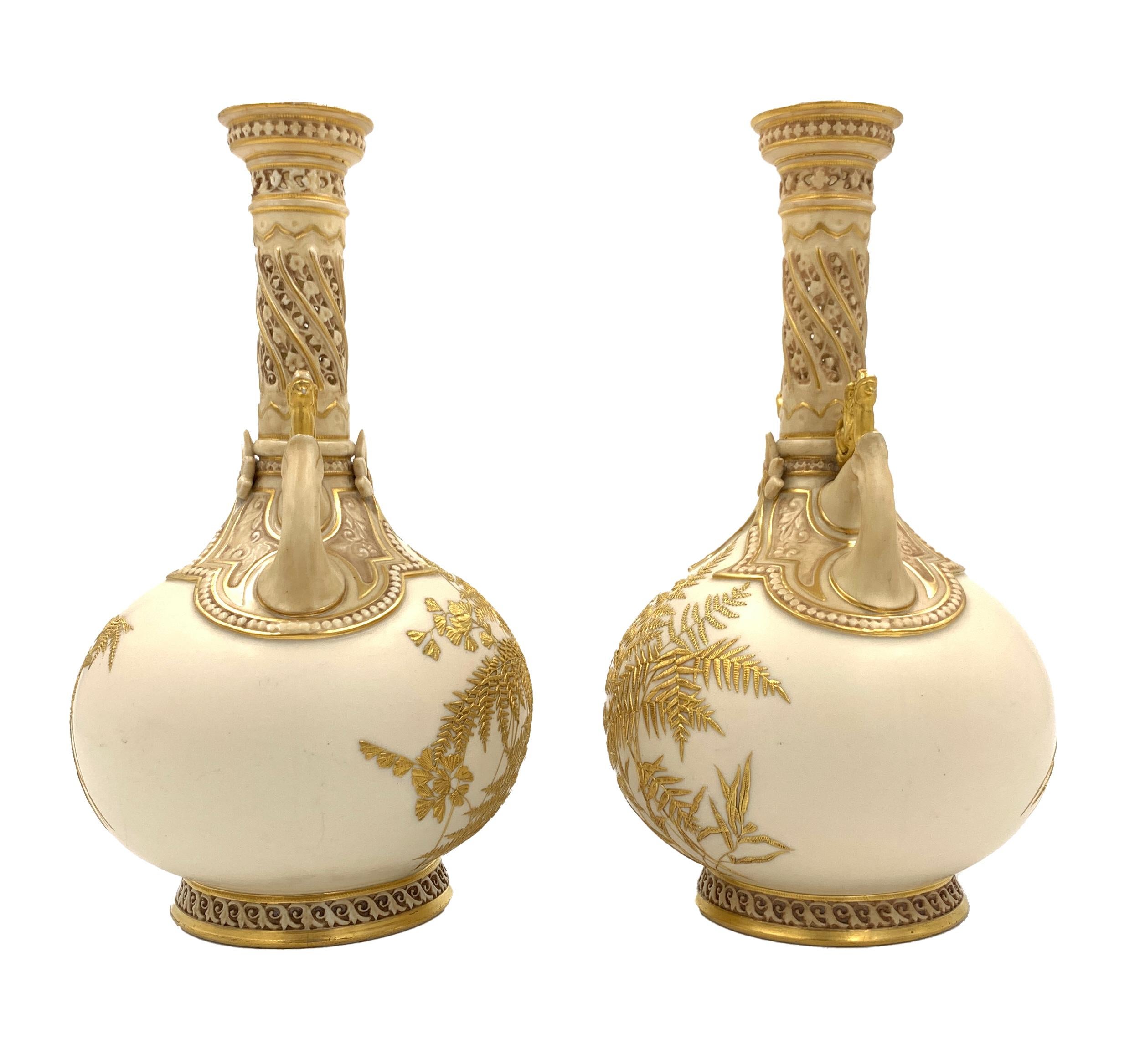 A fine pair of late 19th century Japanese style gilt decorated vases with mythical beast headed handles and strong gilt fern decoration, finely pierced long necks.