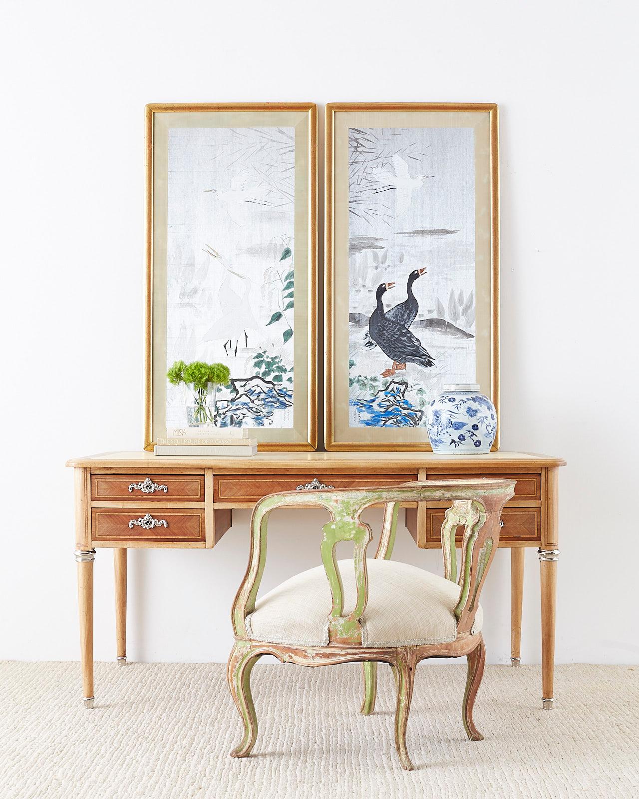 Stunning pair of paintings made in the Japanese Meiji period style. Featuring white herons and a pair of ducks. Painted on metallic silk with ink and colored pigments with a silk border. Set in giltwood frames and back signed by artist on bottom.