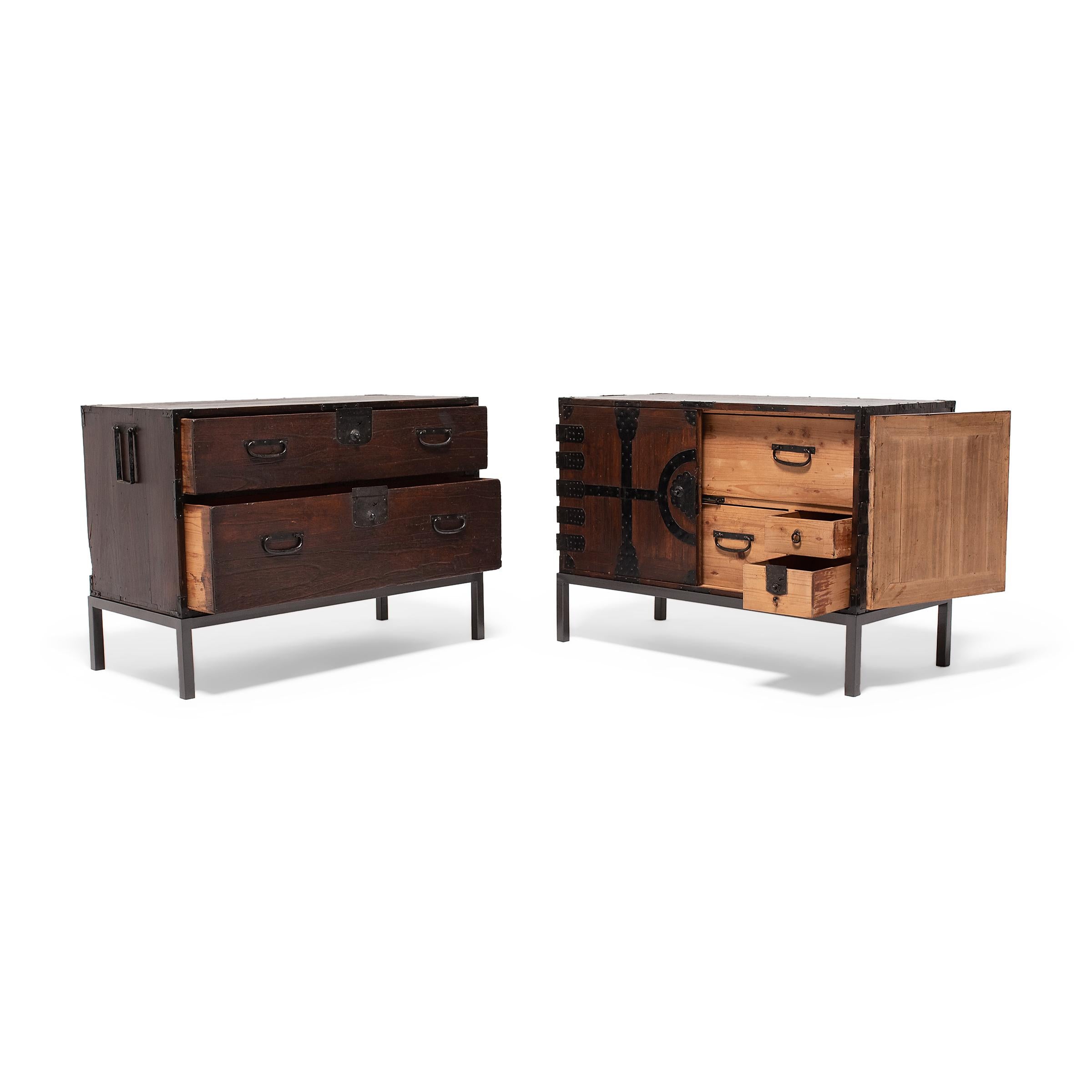 Designed to be versatile and portable, Japanese tansu chests were multipurpose storage cabinets that moved throughout the home as needed. This pair of low cabinets are two halves of a traditional stacking tansu used for storing clothes and bedding.