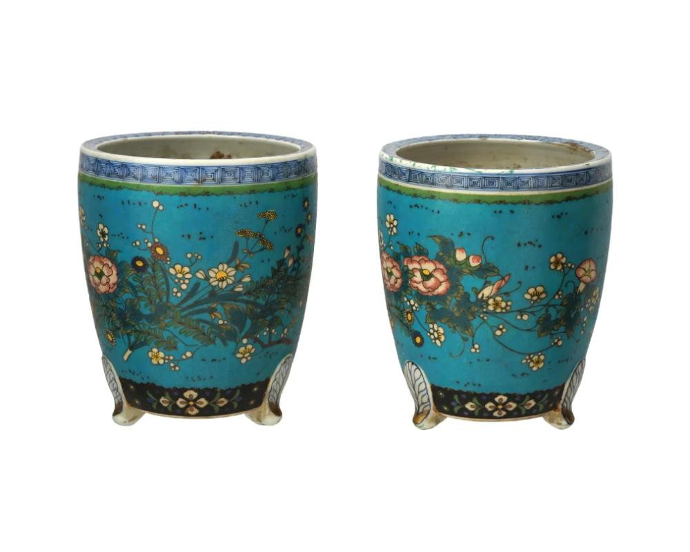 Un par de macetas o jardineras japonesas Totai esmaltadas sobre porcelana. La vajilla está esmaltada con motivos polícromos de flores en flor y follaje sobre fondo turquesa realizados con la técnica cloisonné. El cuello está adornado con un