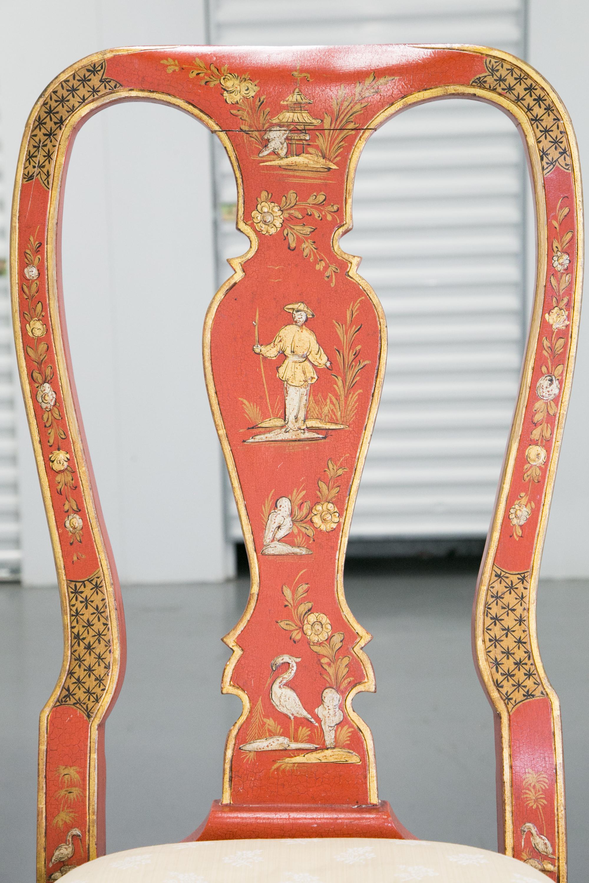 This is a Classic pair of chinoiserie or 'japanned' carved and upholstered side chairs painted overall in a Chinese red with raised figures of villagers and scenic views. The lacquered finish is highlighted with gilt decoration. The chairs are a