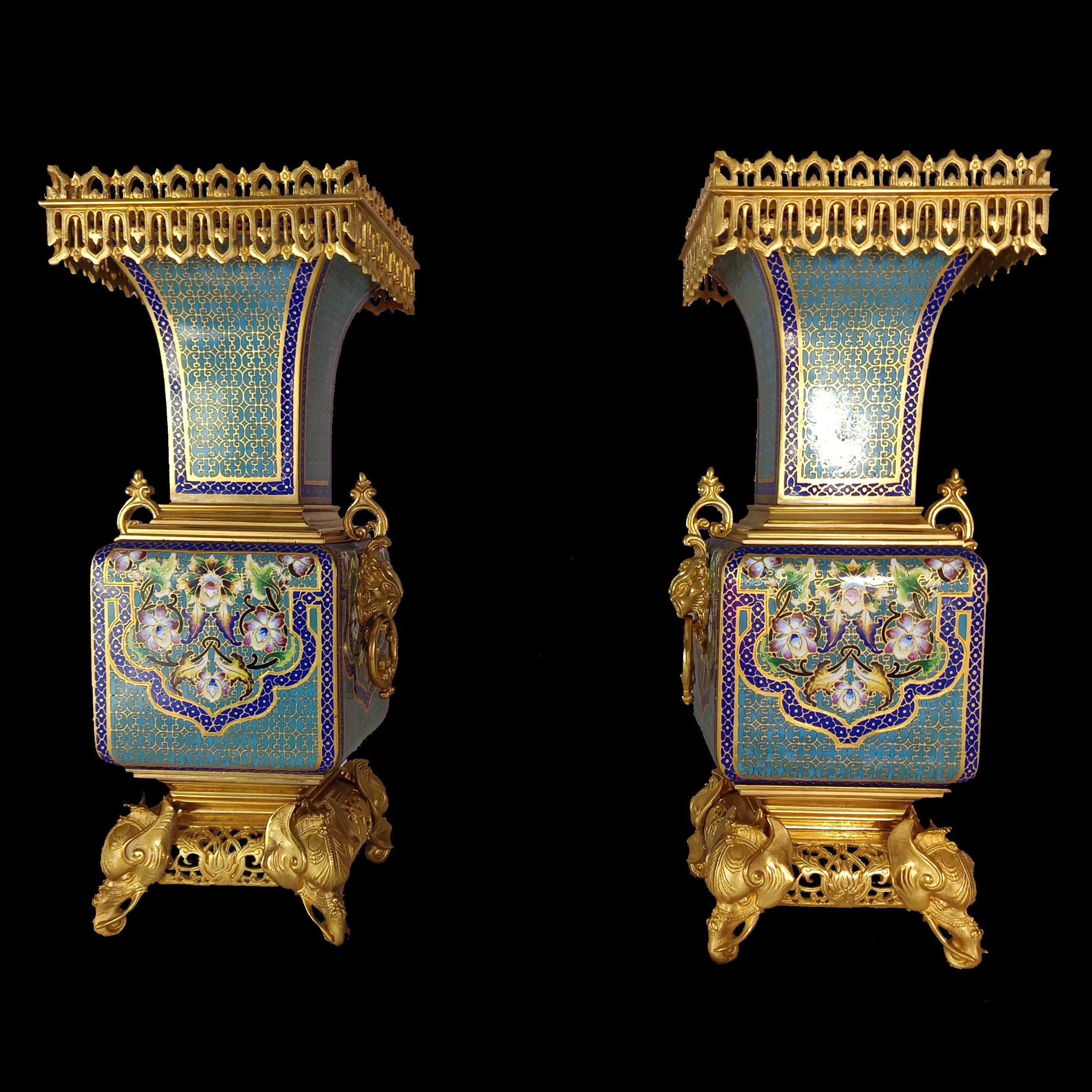 Very fine pair of large baluster vases in cloisonné enamel with decoration on the belly of floral Arabist motifs on a blue and gilded geometric background. 

Rich gilt bronze mount on the base and neck with side handles in the shape of Fo dog